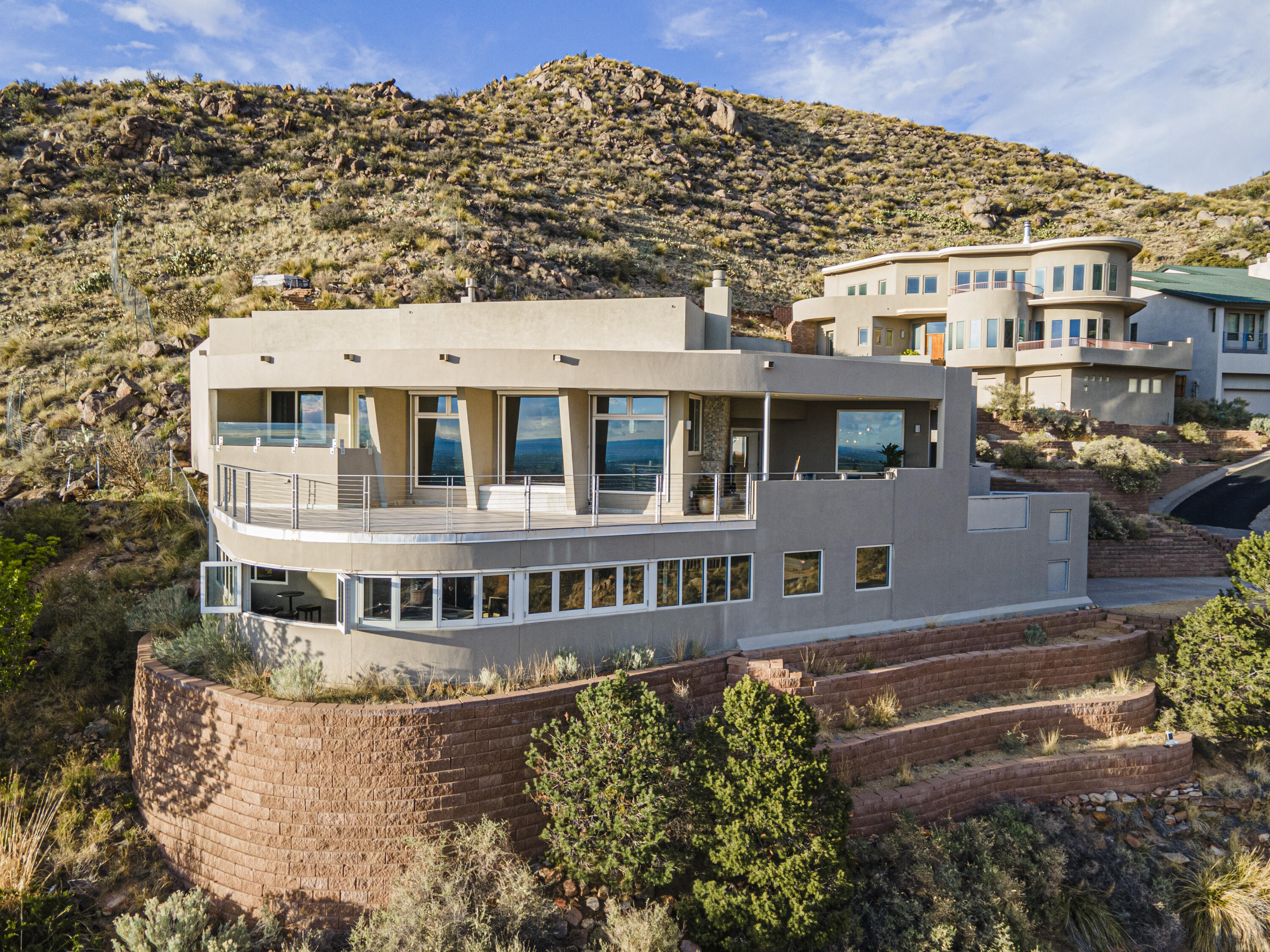 Amazing Custom Contemporary Home Nestled on .55 acre cul-de-sac lot adjacent to open space & national forest in the ABQ Foothills. The natural beauty this rare gem offers is more than just a place to live, it's a lifestyle! This property exudes both privacy & luxury, amidst breathtaking mountain & city views. Gorgeous panoramas from every room are captured with expansive windows creating indoor/outdoor living spaces including patios/decks to enjoy unparalleled sunsets and wildlife. Superior Construction by local Architect and Commercial Builder shows in the Details. Flowing open floor plan w/gorgeous chef's kitchen includes an abundance of storage, island, granite, stainless steel appliances & pantry. Soaring ceilings & wall of windows help capture the VIEWS from every angle.