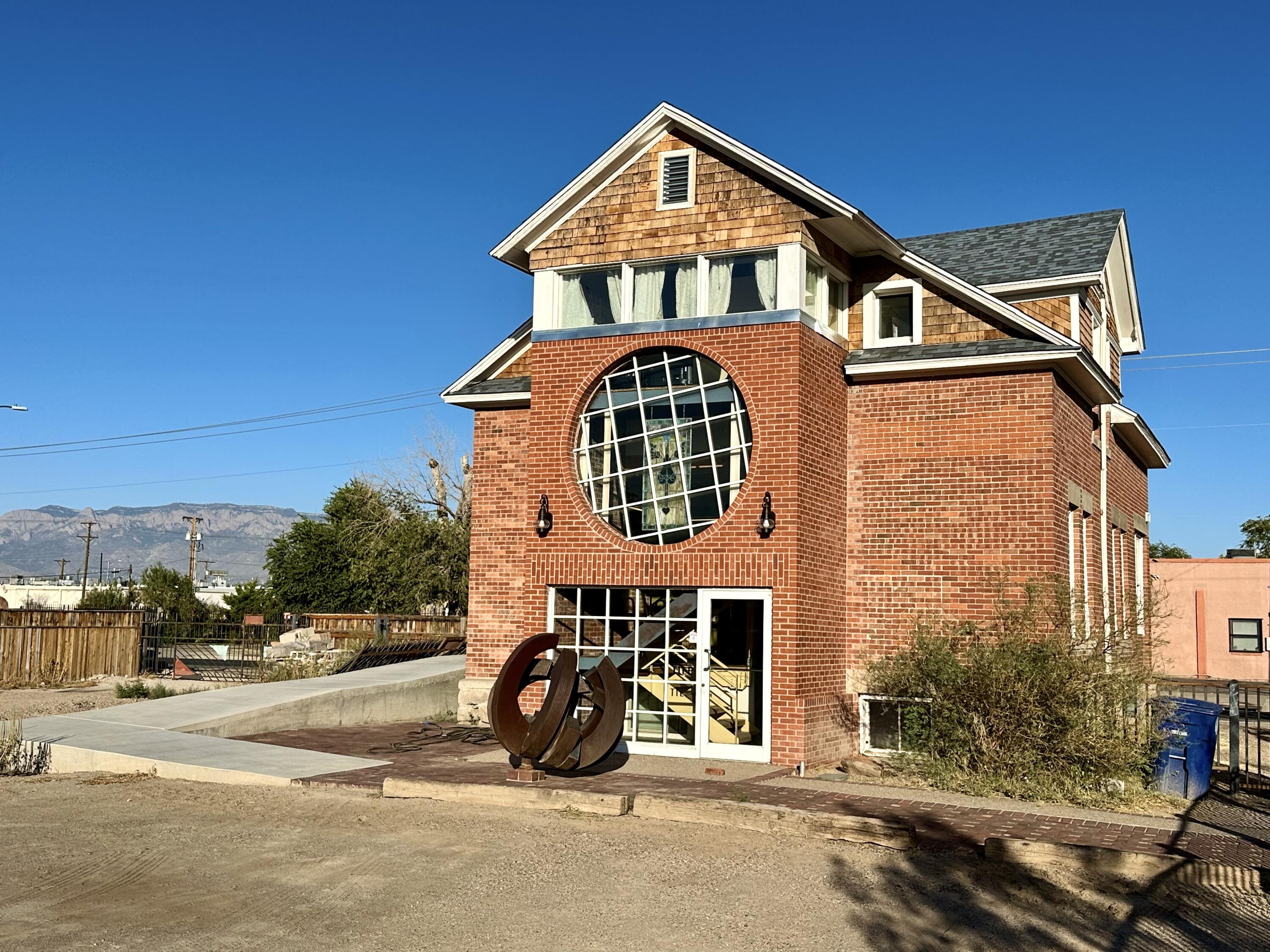 Step into the charm of this early 1900s farmhouse on a large corner lot in Albuquerque's vibrant Wells Park neighborhood. Featuring historic double-hung windows, exposed brick, and cedar-shingled gables, this property blends timeless elegance with all-new systems--roof, HVAC, electrical, plumbing--plus modern finishes throughout. Currently configured with three rental-ready units (21 bed/1 bath upstairs, 1 bed/1 bath on the main level, 1 bed/1 bath on the basement level)), this MX-T zoned live/work space includes an office area and renovated basement, ideal for small businesses. Fully furnished apartments have provided consistent income for 4 years, and ample gated parking offers RV accessibility. This walkable location even includes an adjacent vacant lot available for sale, giving