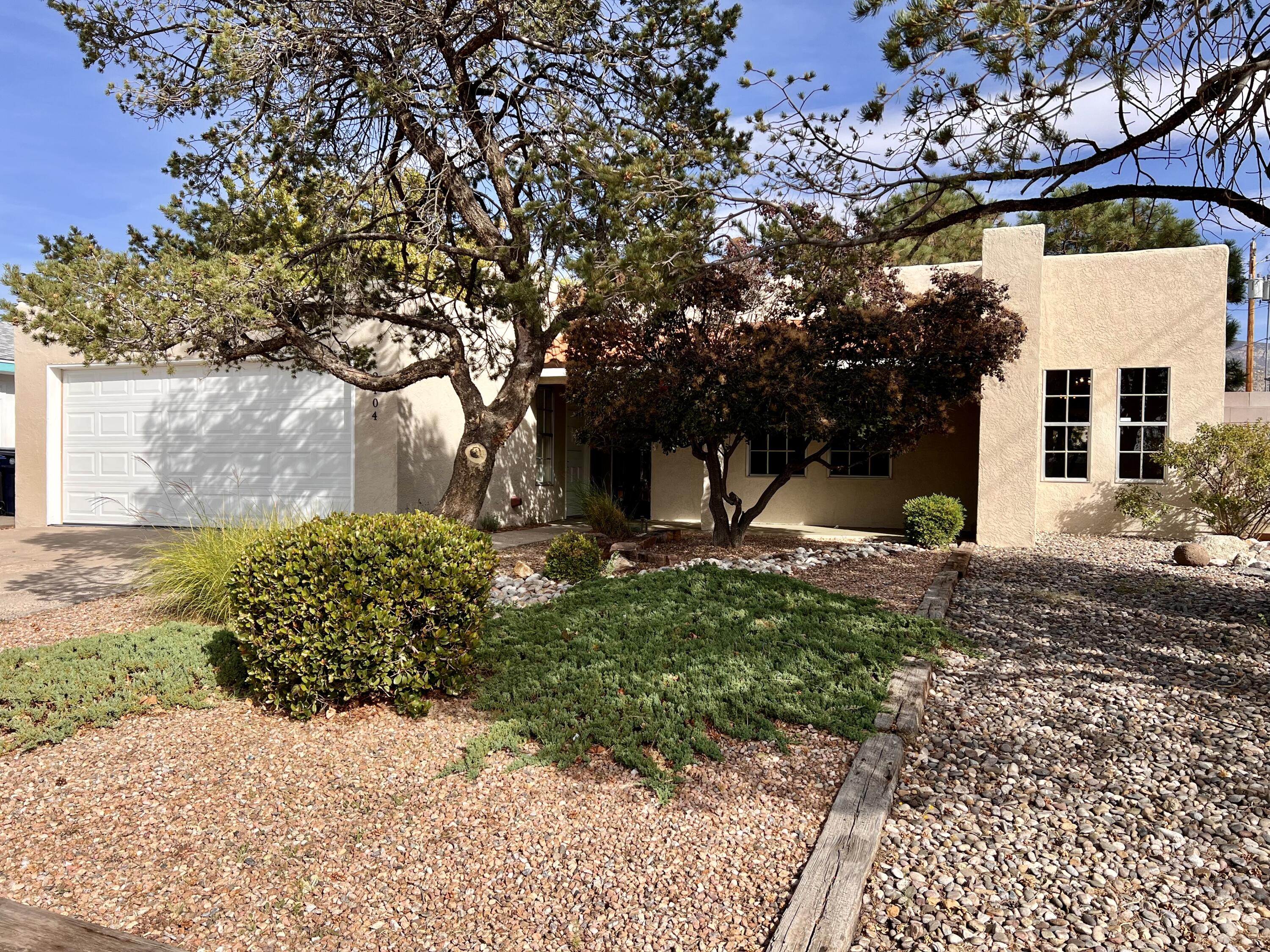 Welcome to 2404 Paisano NE, a beautifully updated gem in Albuquerque's sought-after Northeast Heights! This 3-bedroom, 2-bath home boasts 1,806 sq. ft. of bright, inviting living space. Step inside to a spacious open floor plan with a cozy wood-burning fireplace, perfect for chilly evenings. The updated kitchen features modern appliances, ample cabinetry, and an eat-in dining area. Relax in the primary suite with a walk-in closet and private bath. Outside, the lush backyard with a covered patio is perfect for entertaining or quiet evenings. Most recent upgrades include tiled backsplash in the kitchen and bar, new sockets and switches, new Pella sliding doors, French drain, and much more!! Located close to parks, shopping, and dining, this home blends comfort and convenience--don't miss out