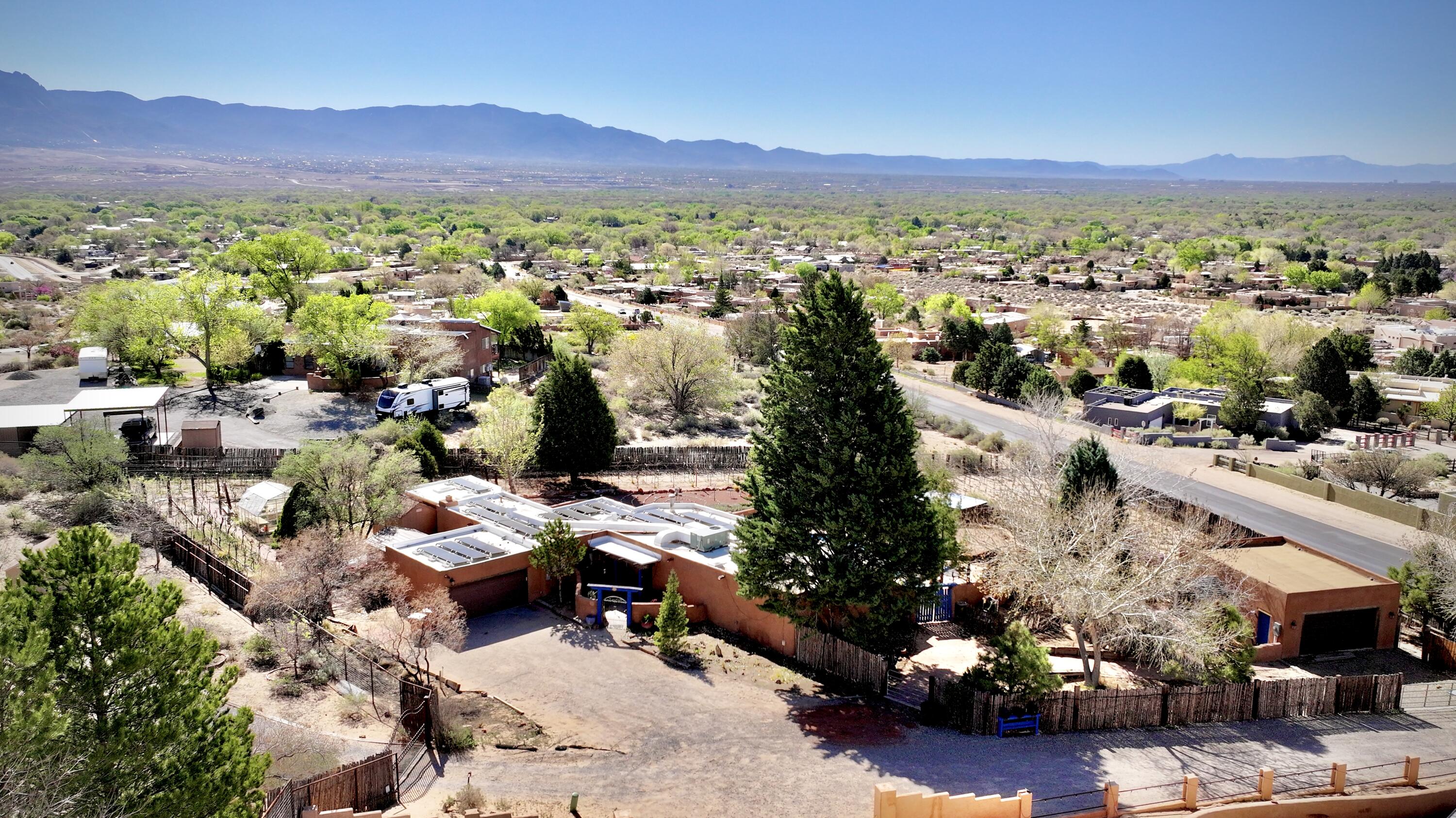 If you're looking for a New Mexican style property to entertain and to call your own piece of heaven, you've found it! Beautiful adobe home construction, tile floors, exposed adobe interior walls, beautiful viga corbels, passive and active solar to keep you warm and the utilities down! SOLAR SYSTEM WILL BE PAID OFF AT CLOSING!!! Walk out to a beautiful outdoor patio to entertain and enjoy the Mountain View's either from your patio, your inground private pool, or your amazing vineyard!! Take a walk thru the beautiful vines to your heated and cooled workshops (or make it your 700 sqft casita, with water and plumbing already established)!! Beautiful construction, beautiful private areas, plenty of opportunity to entertain... come see why this is your next new home!