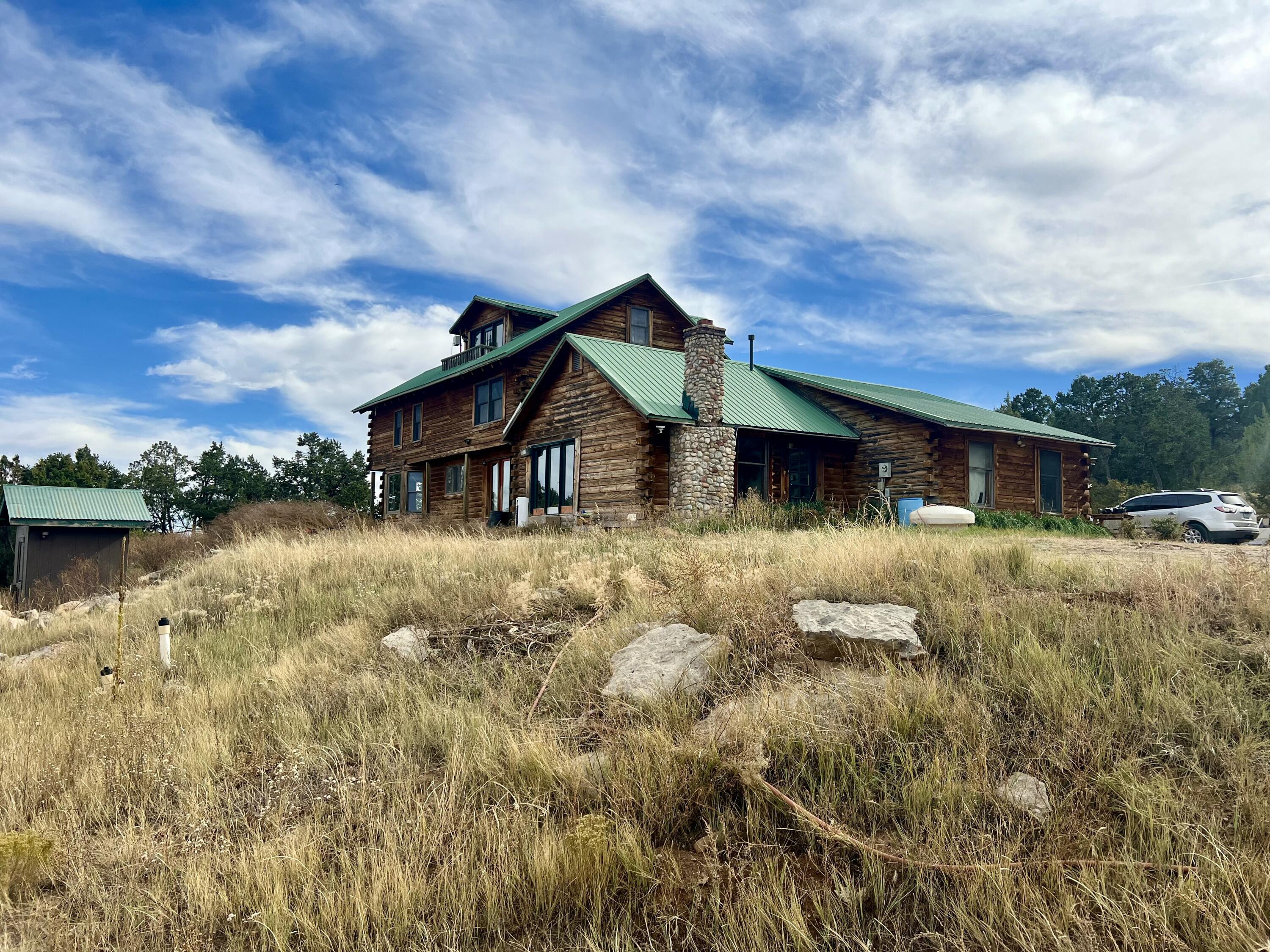 Escape to the mountains with this remarkable 5-acre property featuring two distinct homes! The main residence is a large, 3-story log cabin, showcasing outstanding craftsmanship and breathtaking views from every level. This spacious retreat has plenty of character and only needs minor repairs to reach its full potential. Just steps away, the accessory dwelling unit (ADU) offers a cozy 2-bedroom, 1-bath layout with a kitchen, living area, and office, perfect for guests or rental opportunities. An outdoor pool adds to the allure, creating a peaceful haven in the mountains. The property is currently being cleaned up, offering a blank canvas for your personal touches. Don't miss this rare opportunity!