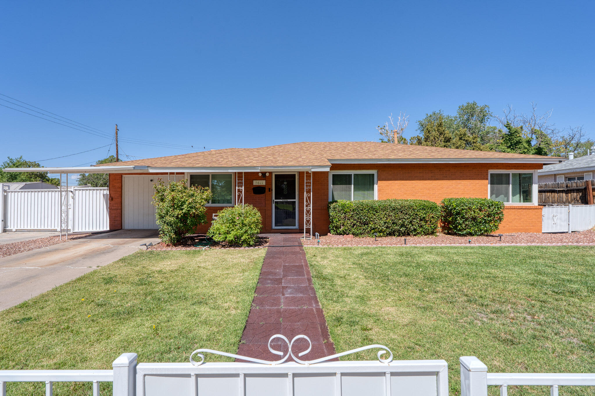 Nestled on nearly 1/4 acre, this charming 1-story brick home is perfectly situated across from a lovely park.  Rare find with its combination of modern upgrades, ample space, and prime Uptown location.  Upgrades include energy efficient windows 2017, new roof 2018, patio door 2018, & water heater 2021.  Bedroom 4 features a full ensuite bath and private entrance, making it perfect for a rental, guest room, or in-home business.  Automatic gate makes backyard access easy and provides additional parking.  Spacious covered patio includes a gas grill, ideal for relaxing and entertaining.  Beautiful front and back landscaping with fencing.  Two storage buildings. Two driveways offer plenty of parking space. Kitchen appliances, washer/dryer, & security cameras included.   Schedule a tour today!