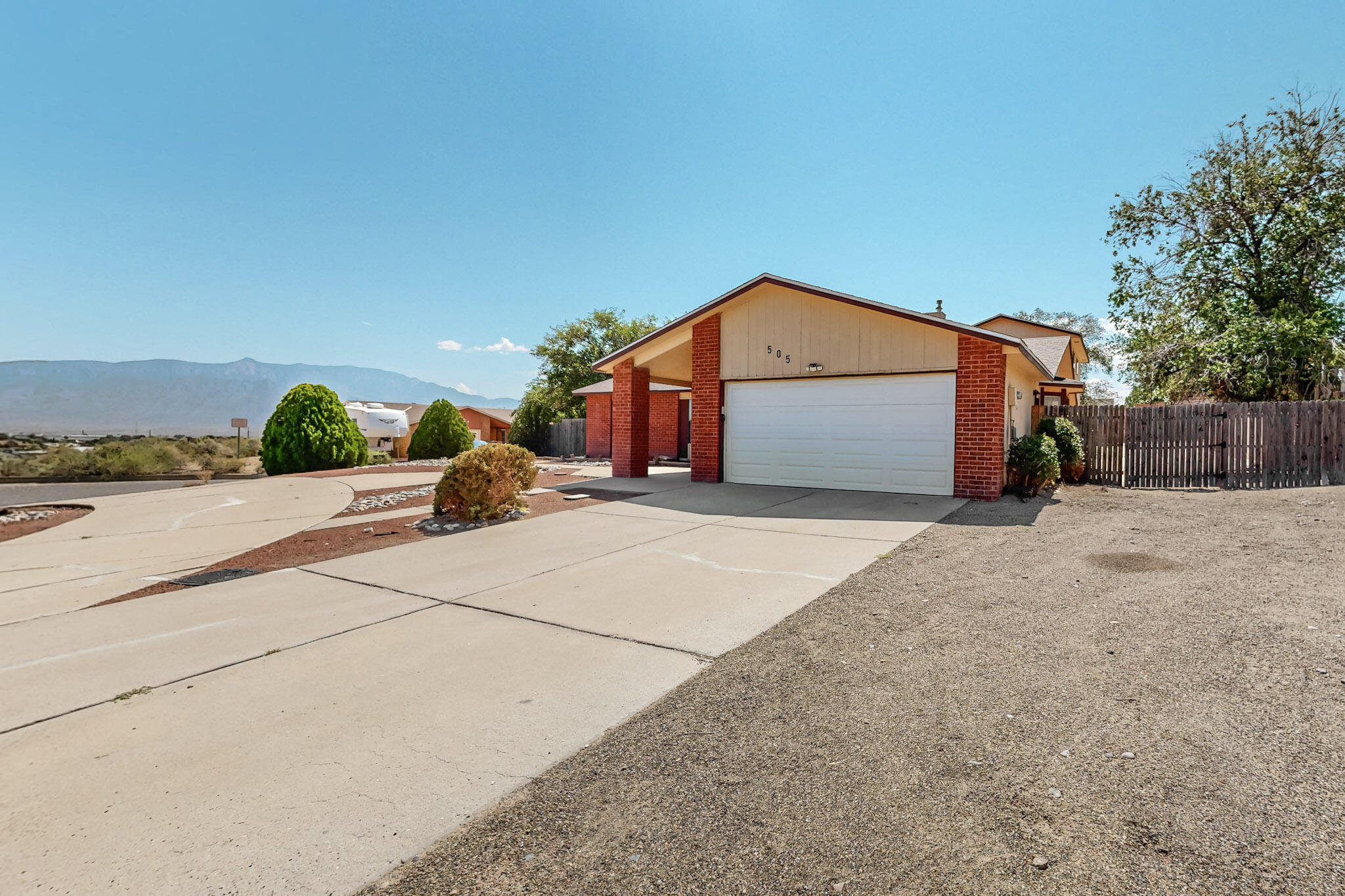 Welcome to this spacious 5-bedroom, 3 bath home on an oversized lot, boasting stunning views and an expansive backyard with both a deck and a covered patio--perfect for outdoor entertaining. The home offers convenient backyard access, ideal for versatile use of the outdoor space. Inside, enjoy two inviting living areas, a cozy fireplace, and a separate dining room. The main level hosts the primary bedroom for easy access, while a large upstairs bedroom with a private 3/4 bath, deck, and scenic views provides a tranquil retreat. This property blends comfort and  functionality.