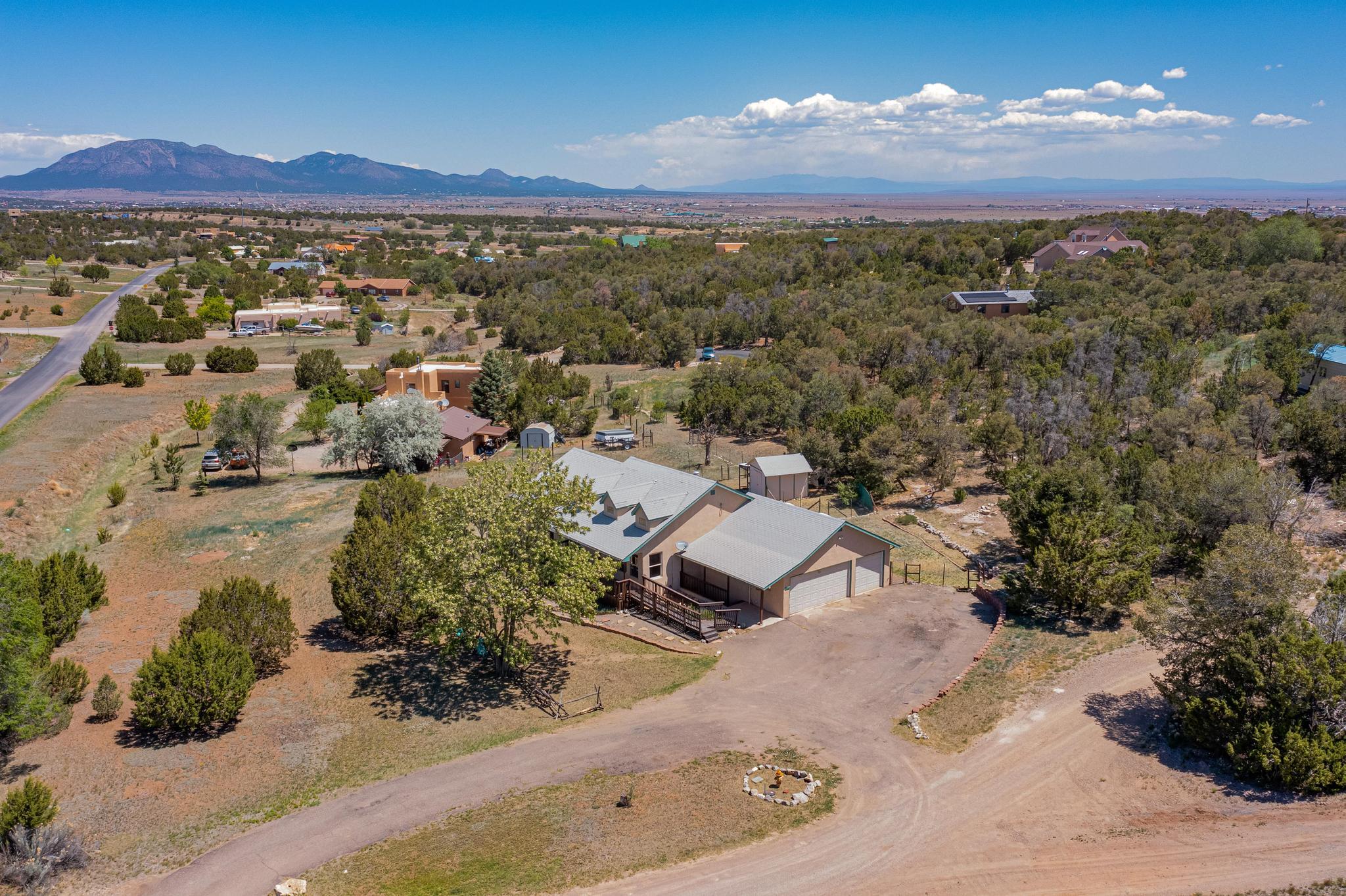 RELIST! Experience the allure of rural living in this beautiful Northern New Mexico-style home. This spacious property offers ample room for comfortable living, both indoors and outdoors. Step inside to find high ceilings that create a bright and airy atmosphere, complemented by new carpet and fresh paint. Recent updates include modernized bathrooms and resurfaced countertops, adding a fresh touch. The huge downstairs family room provides a perfect space for relaxation and entertainment. Located less than a mile from hiking trails and open space, this home invites you to embrace the natural beauty of the surroundings. Enjoy the convenience of paved roads leading up to the driveway and take advantage of the oversized 3-car perfect for extra storage. Make this charming home yours today!