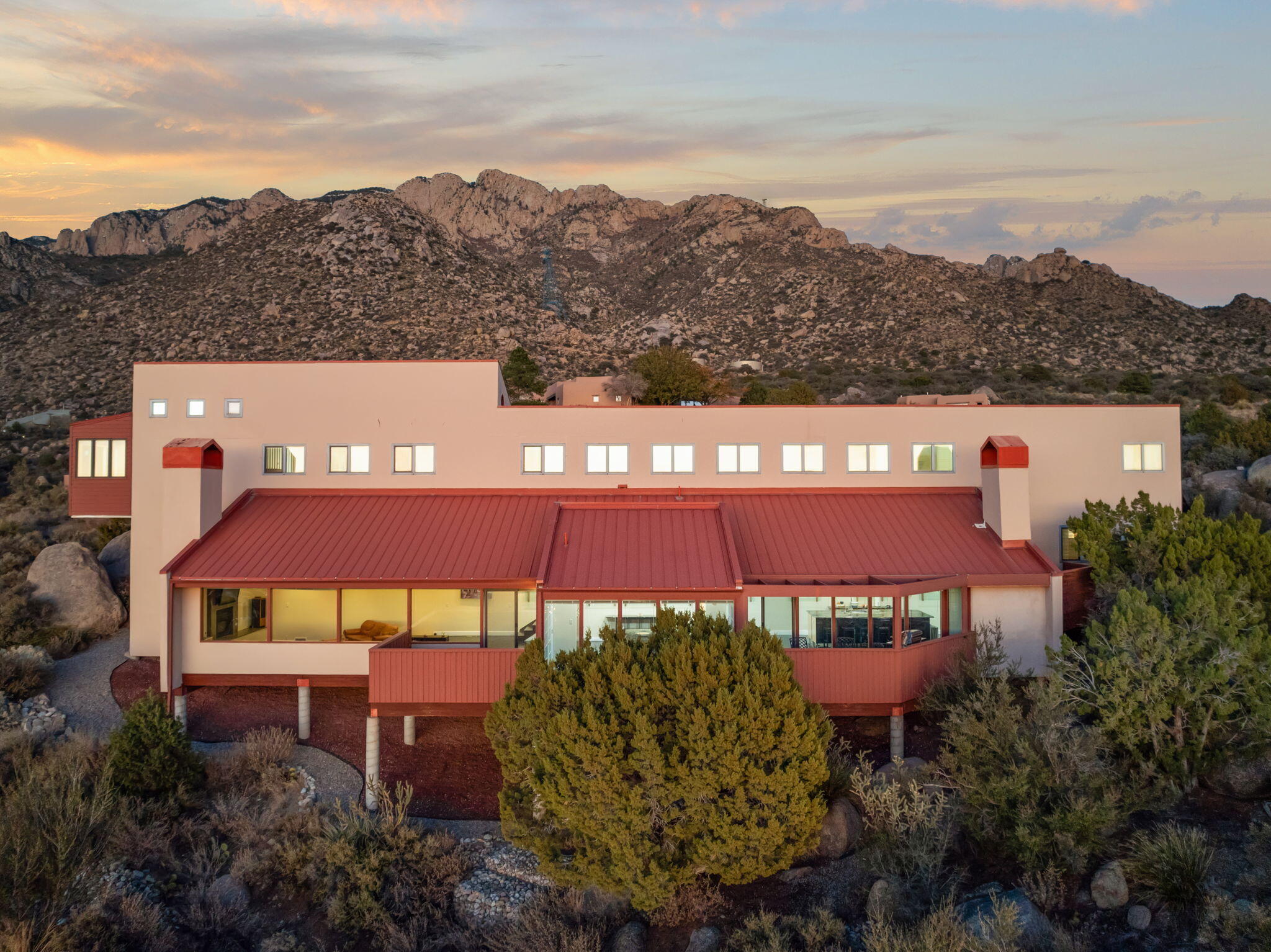 Situated on a premier Sandia Heights lot, this custom contemporary Ron Romero home boasts stunning views of the city, mesas & Sandia Mtn backdrop. Thoughtful architectural/design details & spacious multi-level floorplan with living spaces offering breathtaking views through the multiple walls of windows. Featuring sloped wood beam ceilings, elegant living room w/efficient gas insert FP opening to a formal dining space w/built-ins, & updated chef's kitchen w/professional range, Euro style cabinetry, granite & butcher block counters. Connecting view decks are optimal for entertaining, Al fresco dining, & relaxing. Primary suite, on its own level, includes a hot tub room & view deck. Landscape by Hilltop. Convenient location that backs to open space w/easy access to trailhead & Tramway Blvd.