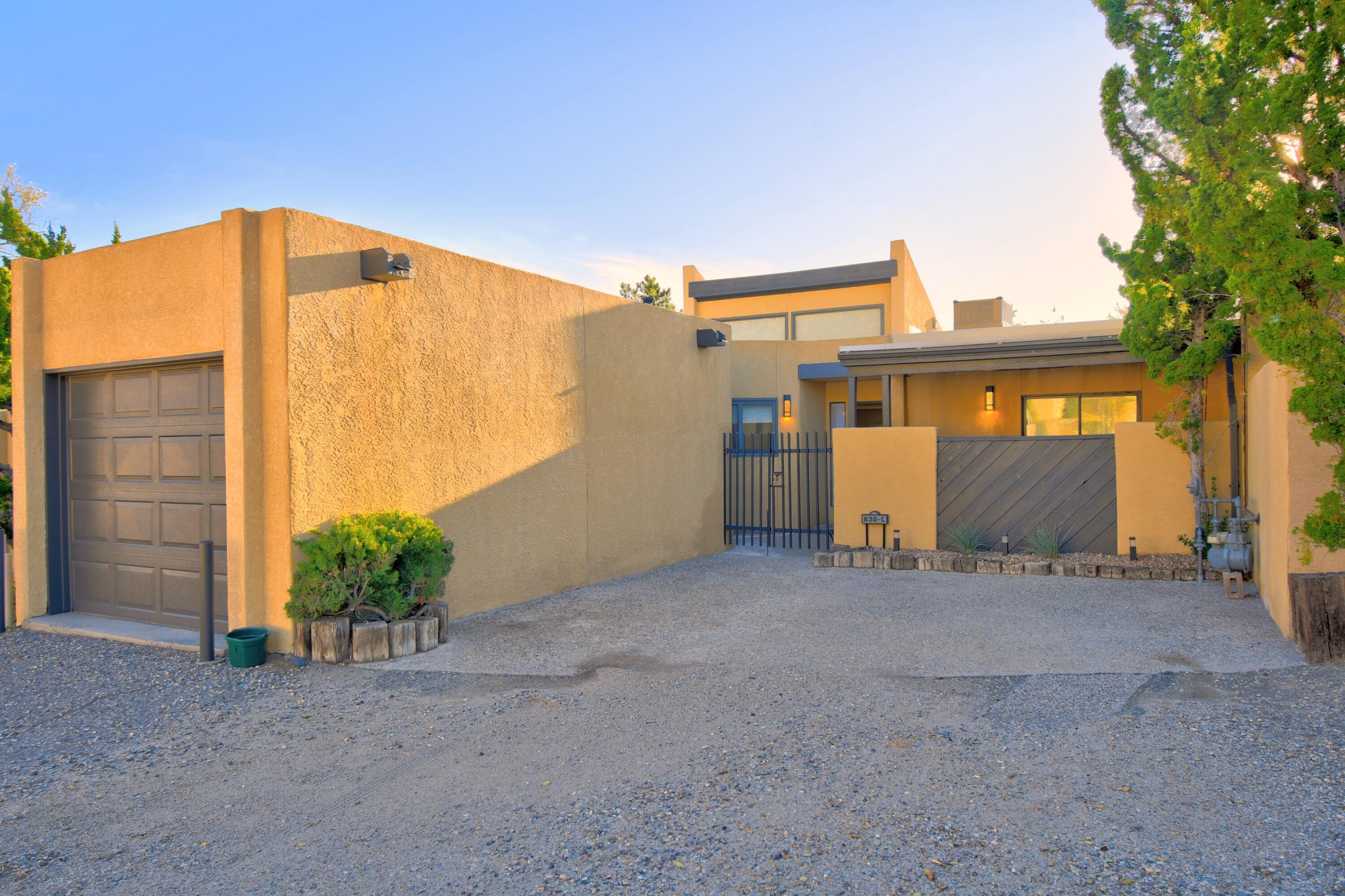 Step into excitement with this delightful Sandia Heights townhome that's bursting with updates! You'll be amazed by the airy, open floor plan complemented by raised ceilings that enhance the natural light and amazing views! Revel in the modernized kitchen boasting newer appliances, perfect for hosting friends or family. The bathroom is a private oasis featuring a European tub for relaxation. Gather 'round the wood-burning fireplace on chilly evenings, or step outside to your cozy courtyard and backyard with breathtaking views. New tankless water heater, HVAC system, upgraded PNM certified electric panel, remote controlled blackout blinds and roof all over the last couple of years! Easy access to Tramway trails!