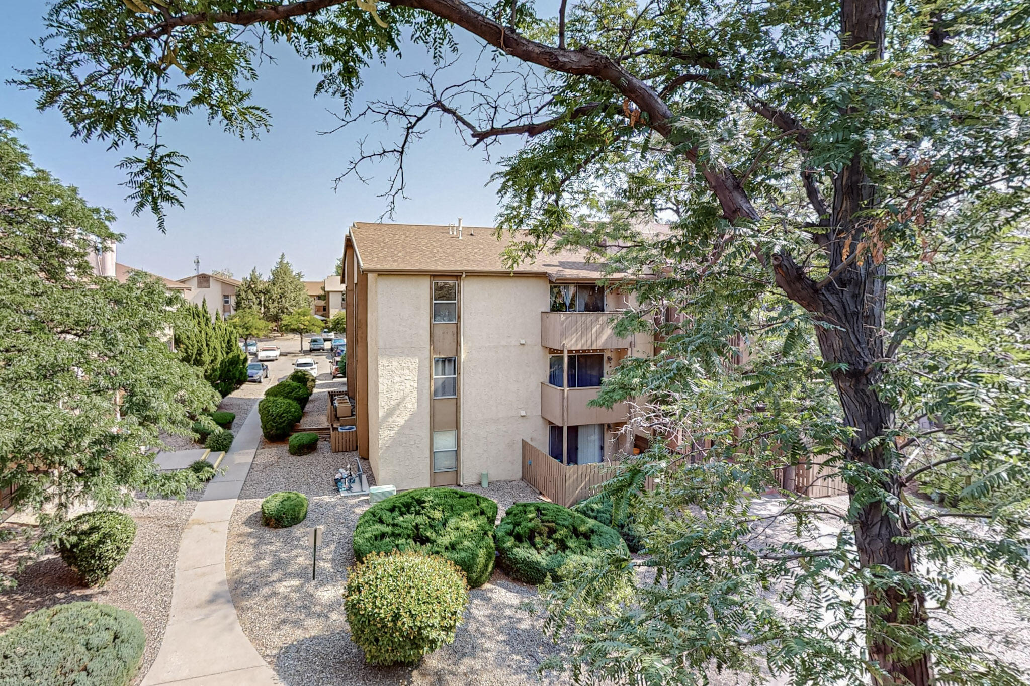 Welcome to this clean and inviting TOP-floor condo in the gated Hillcrest Park community. BRAND NEW HVAC SYSTEM-furnace and refrigerated air to be completed before closing! PLUS the exterior of the building is the process of new paint and stucco! The freshly painted living room features a cozy wood-burning fireplace and a private balcony overlooking a courtyard with views of the Sandias. The spacious owner's bedroom, also freshly painted, boasts a large walk-in closet. Faux wood vinyl flooring runs throughout. Enjoy the mature landscaping and courtyards, a clubhouse, pool, sauna, hot tub, gym, community garden, and on-site laundry. The unit also includes a stackable washer/dryer hookup and storage on the ground floor. HOA covers the following: water, gas, sewer/trash and security