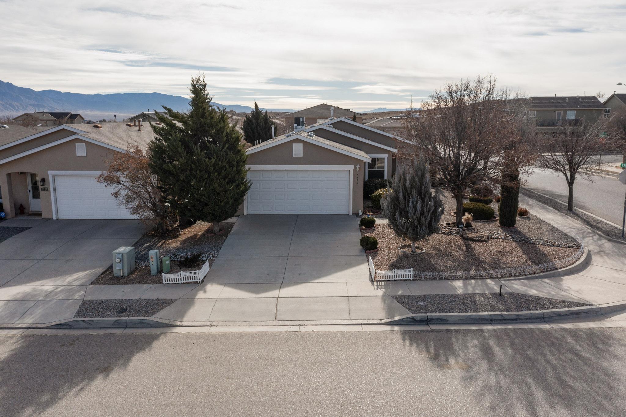 Welcome to this beautifully maintained corner lot home in Rio Rancho! As you step inside, you're greeted by a spacious living room with an open floor plan that seamlessly flows into the kitchen perfect for both everyday living & entertaining. On chilly nights, cozy up by the gas fireplace, and in the warmer months, enjoy the cool breeze as you open the stunning French Doors that lead to a backyard with views of the Sandia Mountains. The outdoor space is ideal for summer barbecues under the porch or gardening in the well kept yard.The primary bedroom offers a generous walk-in closet and a private bathroom with a walk-in shower. The second bathroom features a relaxing tub, perfect for bubble baths or an Epsom salt soak. This home has been lovingly cared for and is ready for it's