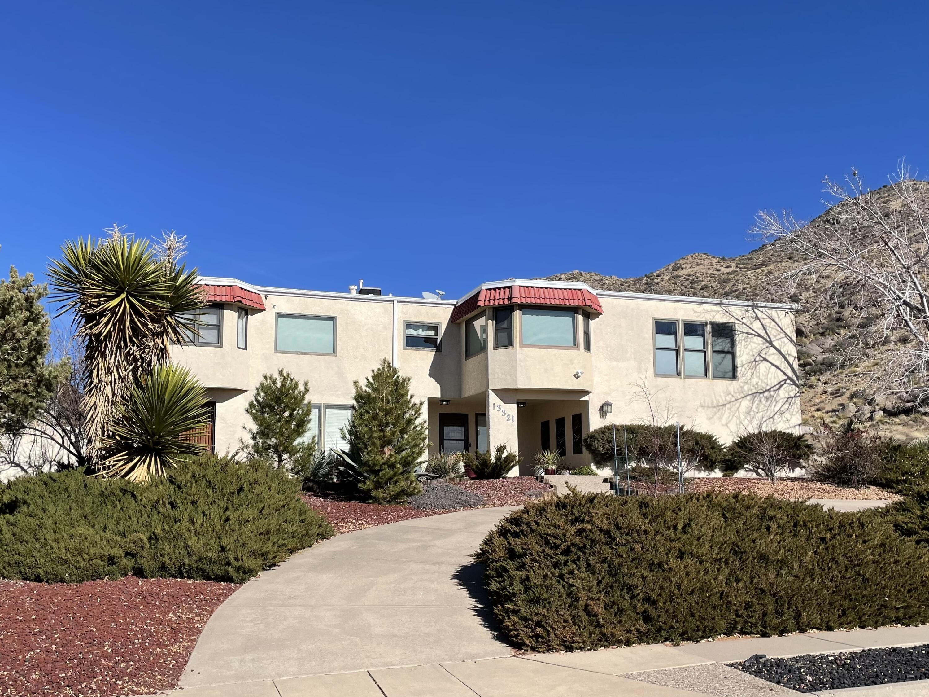 Location, Location, Location!! This versatile home is perched at the base of the Sandias. Hiking trails are within steps of the front door and views abound - watch the moon and parasailers glide over the mountain from the deck and enjoy the blinking lights of ABQ from the dining room! A perfect home for all. This home was once used as an Airbnb successfully, but the sellers have other plans in their life. The sellers have done many updates--new deck off the living room, enclosing the sunporch, amazing landscaping, and many others! It is a large yard (.45 acres) in the city and has been designed to be enjoyed! Seldom do you get that kind of lot in the city. The home can be sold furnished--the seller has custom made much of the furniture. If you want one of a kind, this is it!