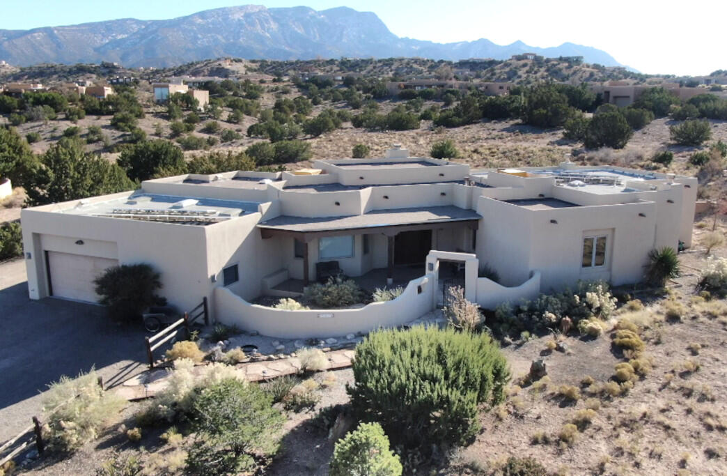 Experience Southwestern elegance in this stunning three-bedroom with two 3/4 & one 1/2 bath home. Sunlight streams through large Hurd windows, framing breathtaking views of the Sandia mountains. To the north the mesas & expansive scenery goes beyond Algodones and San Felipe Pueblo. The great room's vigas and latillas, paired with the living room's adobe accents & Kiva Fireplace embody authentic charm. The spacious primary suite offers a relaxing sitting area, lots of windows bring in natural light, high desert scenery and a gas Kiva fireplace. The kitchen shines with granite countertops and is light and bright. A two-car garage with a work area adds convenience. Surrounded by sweeping mountains and valley views, this home is a true blend of beauty, tradition, and comfort.