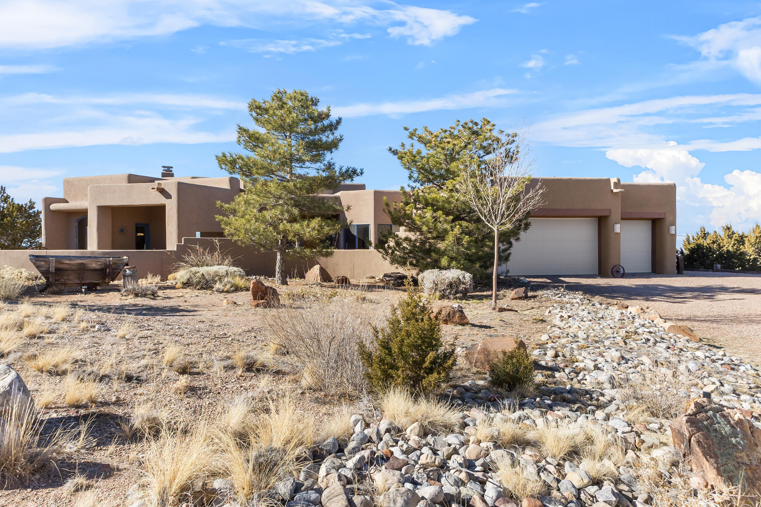 IMMACULATE SOUTHWEST CUSTOM! $775,000. Panoramic views all around from this 3 bdrm, 2 bath ridge-top home on spacious 1.7 acres! Unobstructed views of sunsets & city lights, Mt Taylor & Cabezon, as well as Sandias & mesas! Outstanding, open floor plan w/ separate master suite. Beautiful, rich hardwood floors, exposed beams, raised wood ceilings & wood windows. Large gourmet kitchen with gas cook-top, island, bar, granite counter, big skylight & pantry. Radiant heat & refrigerated air! Panoramic picture windows to take in all of the expansive views! Outdoor living spaces include spacious rear portal, large front courtyard & cozy portal off the dining room. Master bath has large jet tub & separate shower. 3 car garage. Convenient! Just 5 miles from I-25; on paved road. Community water!