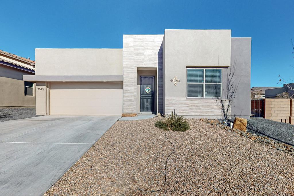 Located on an elevated corner lot in the desirable Lomas Encantadas neighborhood is this stunning Contemporary Pueblo home by the Hakes Brothers. Featuring 3 spacious bedrooms, a versatile flex room, and 2.5  baths. This home is perfect for those seeking comfort, style, and modern amenities. Step into the open, inviting great room featuring soaring ceilings, beams and an upgraded ceiling fan, creating a warm and airy atmosphere. The kitchen is a standout, boasting top-of-the-line stainless appliances, upgraded cabinetry, sleek granite countertops, and a large island with seating for four - ideal for both casual dining and entertaining. The thoughtful floor plan offers excellent bedroom separation, with the expansive primary suite located in its own private wing