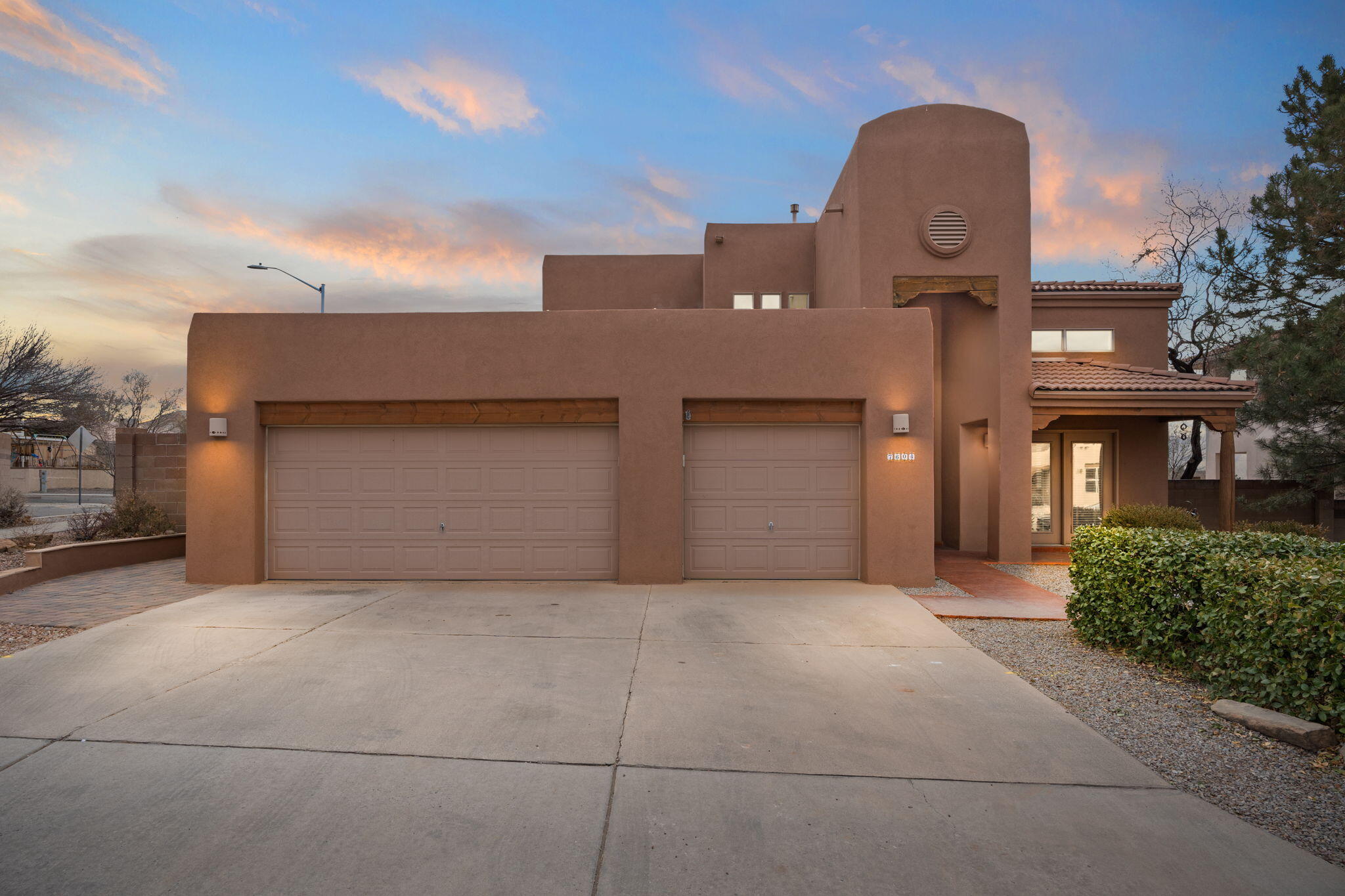 Stunning home in highly sought-after location close to La Cueva High & Domingo Baca Community Center. Step inside to a welcoming living room with soaring vaulted ceilings creating an open feel. The entire downstairs features modern, wood-look, tile flooring, providing style & easy maintenance. The remodeled primary suite, located on the first floor for added privacy, is a true retreat, complete with a luxurious bathroom featuring travertine tiles & granite countertops. The spacious kitchen with granite, stainless appliances, & large pantry opens to the family room, perfect for entertaining. Boasting high ceilings flanked with a gas fireplace and beautiful wood vigas, the living room is full of architectural interest & charm.