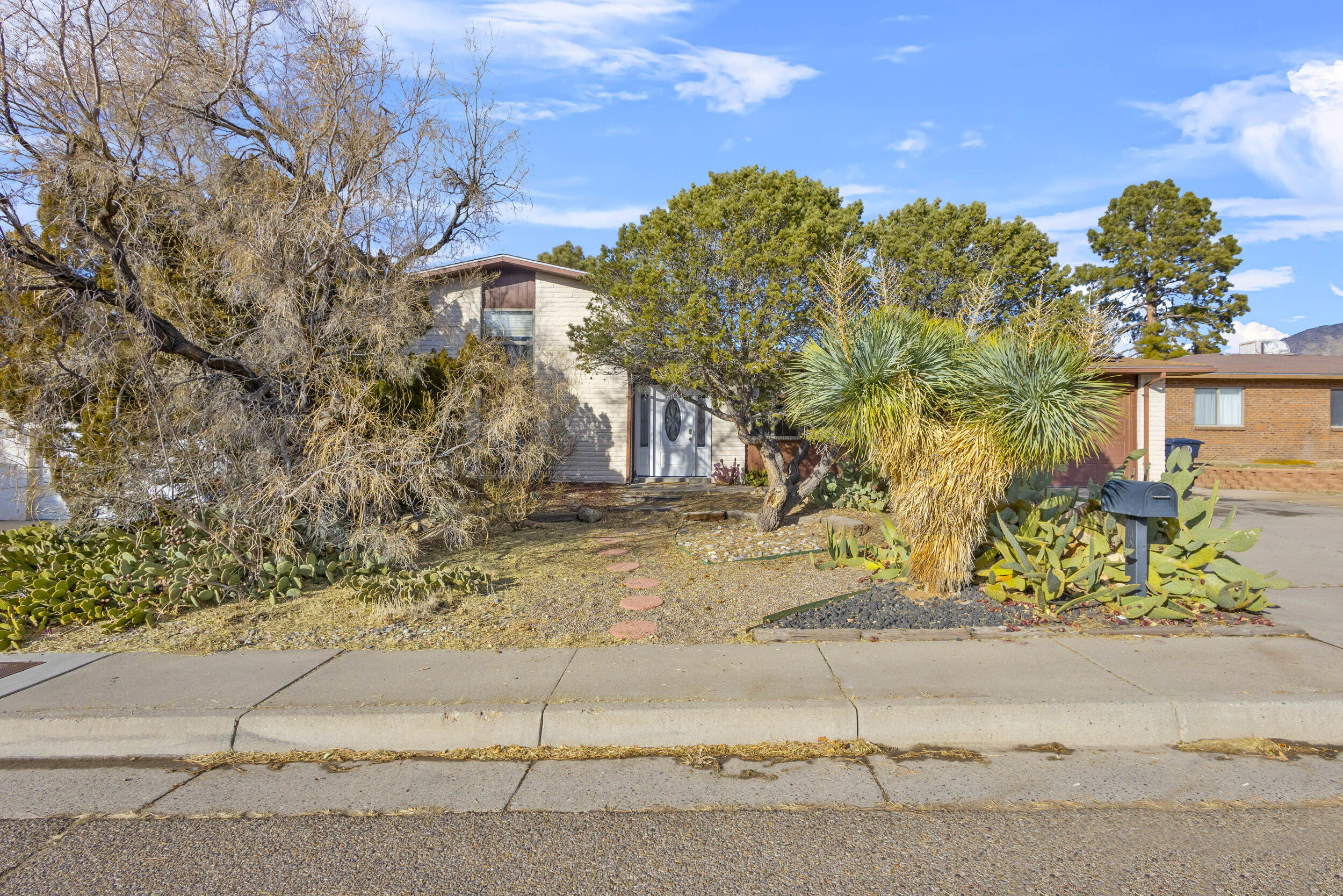 This beautiful split-level home has been well updated and has refrigerated air and OWNED SOLAR! (27k value!) Enjoy low to no electric bills all year long! All kitchen appliances updated and both bathrooms remodeled. Roof was replaced in 2019 along with the water heater. Large backyard with grass, covered patio, pergola, shed, an optional chicken coop area PLUS cherry, peach and pomegranate trees and blackberry, strawberry and grape bushes. Gorgeous wood look laminate floors on the main floor and recently replaced carpet in the bedrooms. Enjoy two living areas including a large family room downstairs with a wood burning fireplace. Great location near a park and close to the foothills and hiking/biking trails. Also easy access to I40 and a quick commute to Sandia Labs, UNM and downtown!