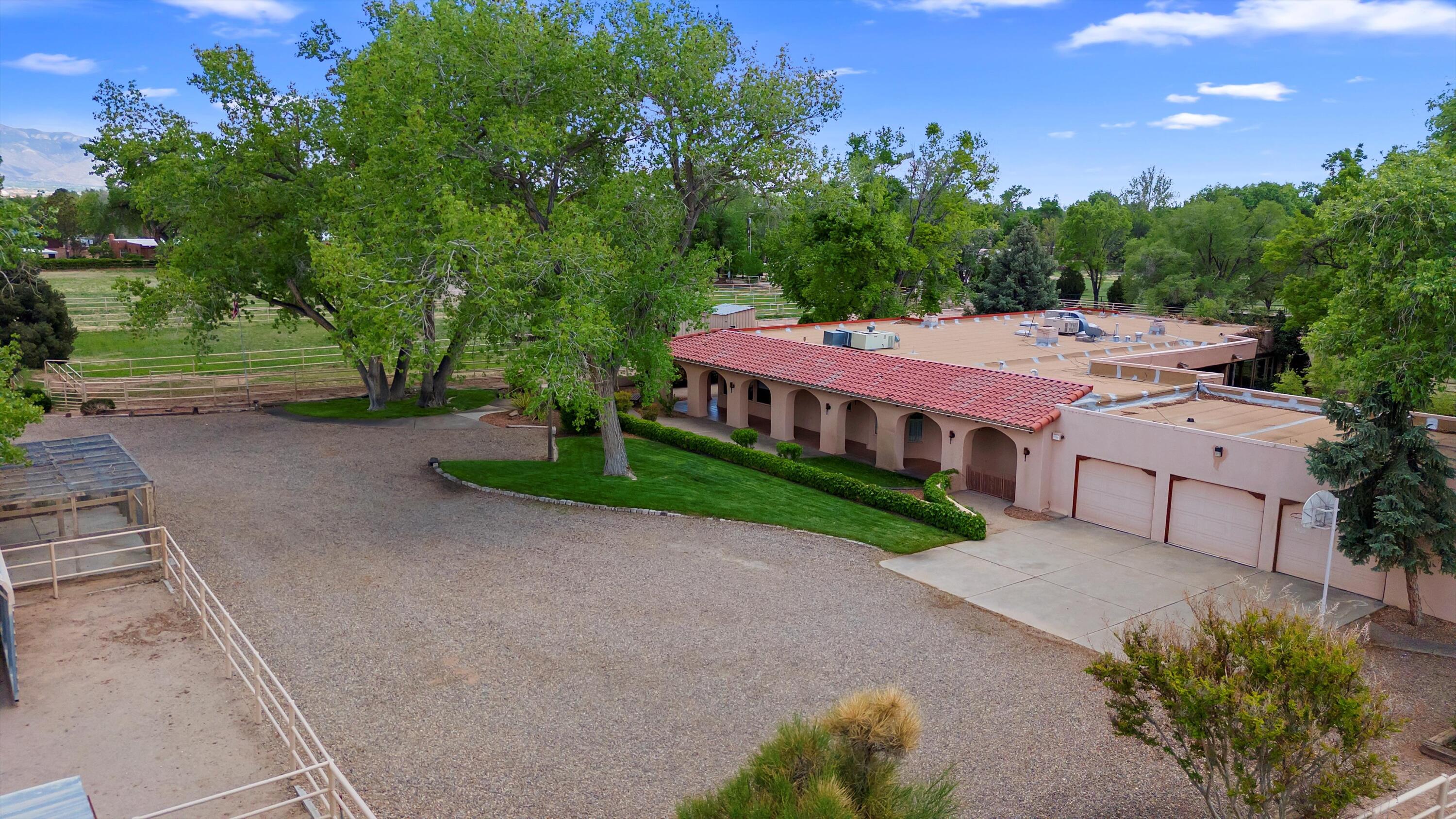 Welcome to this extraordinary 4,500-square-foot SW Pueblo-style estate, located in the prestigious Los Ranchos area in Albuquerque's picturesque North Valley. This single-level home is a rare find, set on 3.6 beautifully landscaped acres with One additional parcel, offering endless possibilities. The second parcel spans 1.82 acres and includes multiple outbuildings: a 40' x 50' horse barn, carports, and livestock stalls. The home's exterior exudes timeless charm, with sprawling verandah, open fields, a pool and hot tub. Inside, you'll find authentic brick flooring, rough cut beams, and T&G ceilings that showcase the craftsmanship of a bygone era. A cozy in-law suite with a kitchenette, bedroom, and living area adds convenience and flexibility.