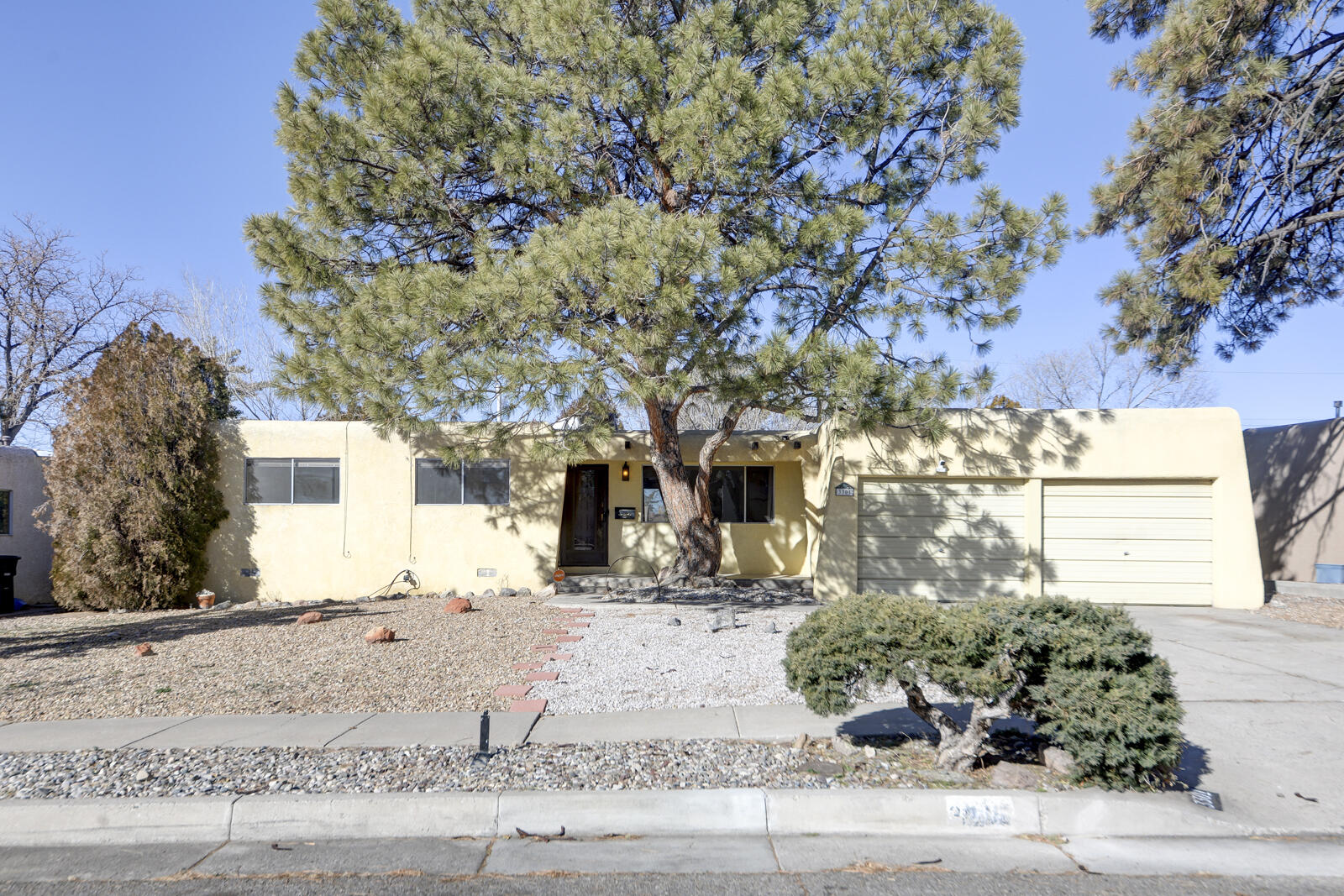 Check out these Harwood Floors!!! This charming Pueblo-style home offers 3 bedrooms and 1.75 baths, with plenty of space for comfortable living. You'll find two spacious living areas, perfect for relaxing or entertaining, all set on gleaming hardwood floors that add warmth and character.Nestled in a quiet neighborhood, this home features a cozy wood-burning fireplace, a large open kitchen ideal for culinary adventures, and fresh paint throughout. Step outside to enjoy the serene beauty of mature trees surrounding the property. With a two-car garage and inviting curb appeal, this home is ready and waiting for you to make it your own.