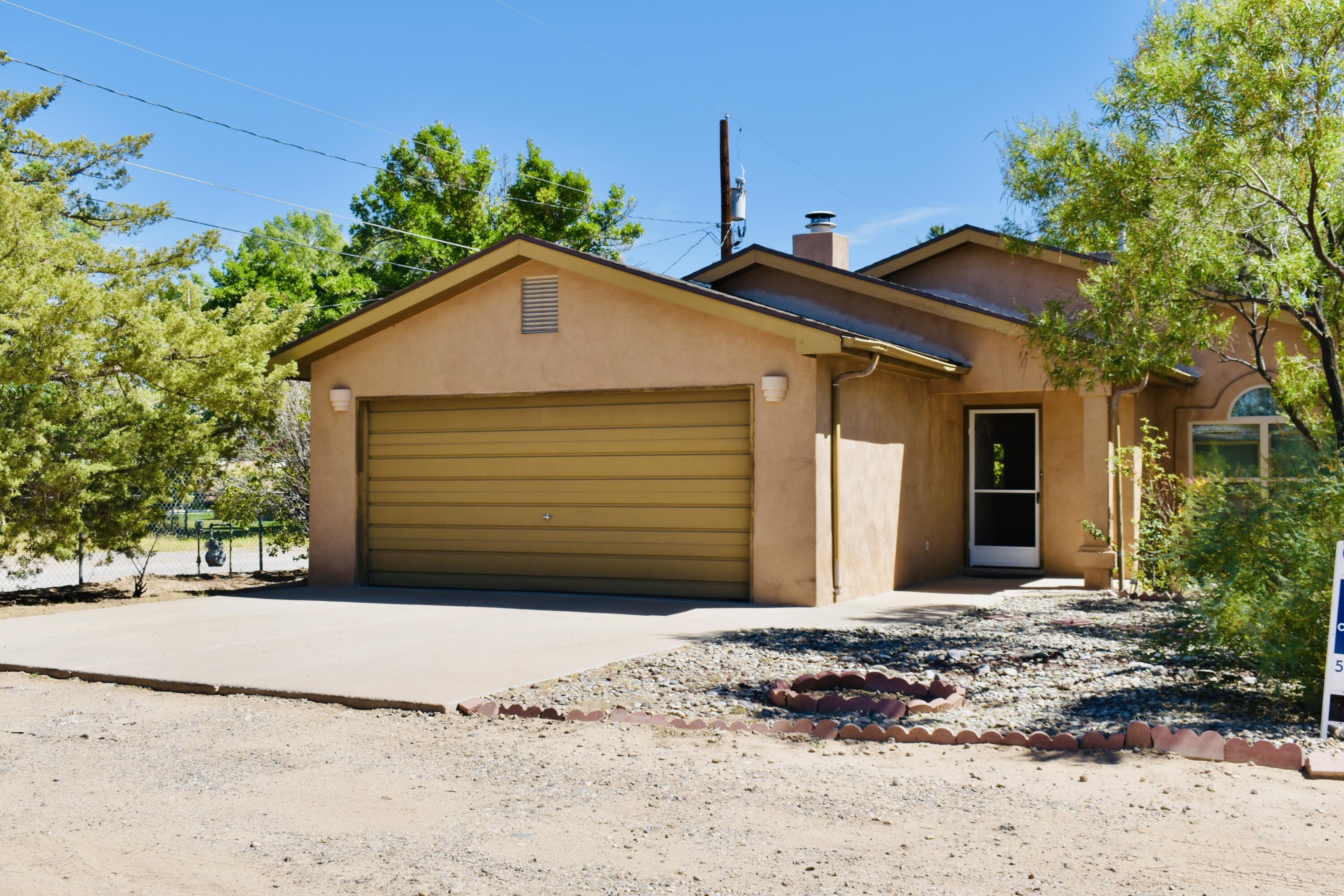 Discover your perfect sanctuary in the picturesque North Valley of Albuquerque, NM! This enchanting 1.4-acre property features a charming 3 bedroom, 2 bath home with 1,498 square feet of living space. Step inside to find vaulted ceilings and a cozy kiva fireplace, creating a warm and inviting atmosphere. Outside, enjoy the lush landscape with multiple fruit trees, grapevines, flowers and mature landscaping. The field and entire perimeter of property can be irrigated with water leased from MRGCD yearly. Relax on the covered patio, and enjoy the serene surroundings. This property also includes a 2-car garage and a carport designed for RV parking, ensuring plenty of space for all your vehicles and storage needs.