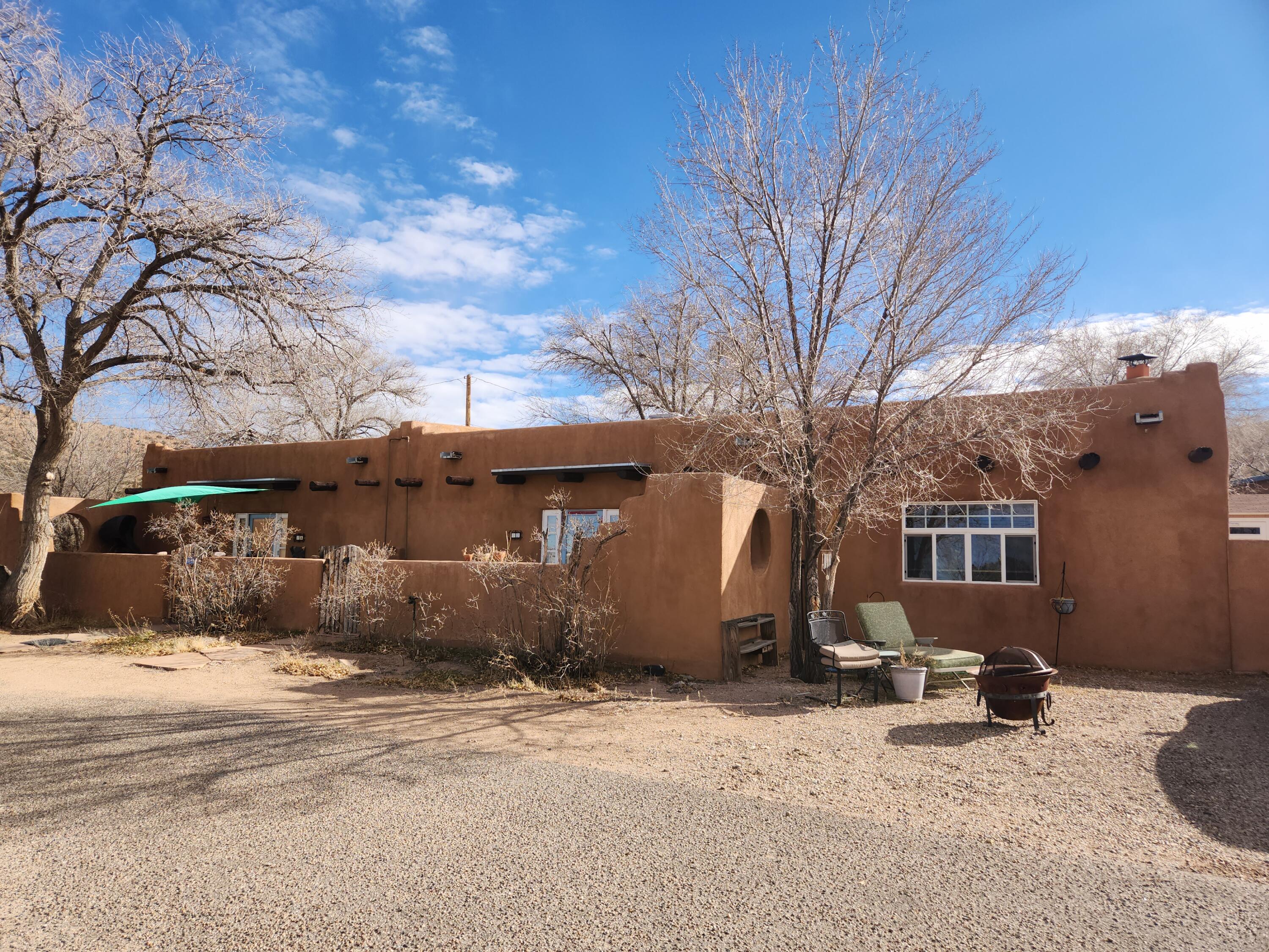 DUPLEX IN PLACITAS! $535,000. Real Santa Fe Style charm with wood ceilings, exposed beams (vigas), beautiful kiva fireplace, brick floors, Mexican tile details, southwest style accents, smooth plastered walls, and it is mostly ADOBE! Main unit is 1278 sq ft with 2 bedrooms, full bath, office, great room, kitchen & dining room. Attached casita is 767 sq ft with 2 bedrooms, full bath, kitchen & living room. Nestled in the heart of Placitas, the units currently rent for $1,540 & $975 per month. Convenient location, just off Highway 165, the land is nearly all level, there is plenty of parking space and room (across Post Office Place) to add a garage, workshop or studio. Both units have courtyards with sweet views! Zoning allows for potential commercial uses... Please do not disturb tenants.