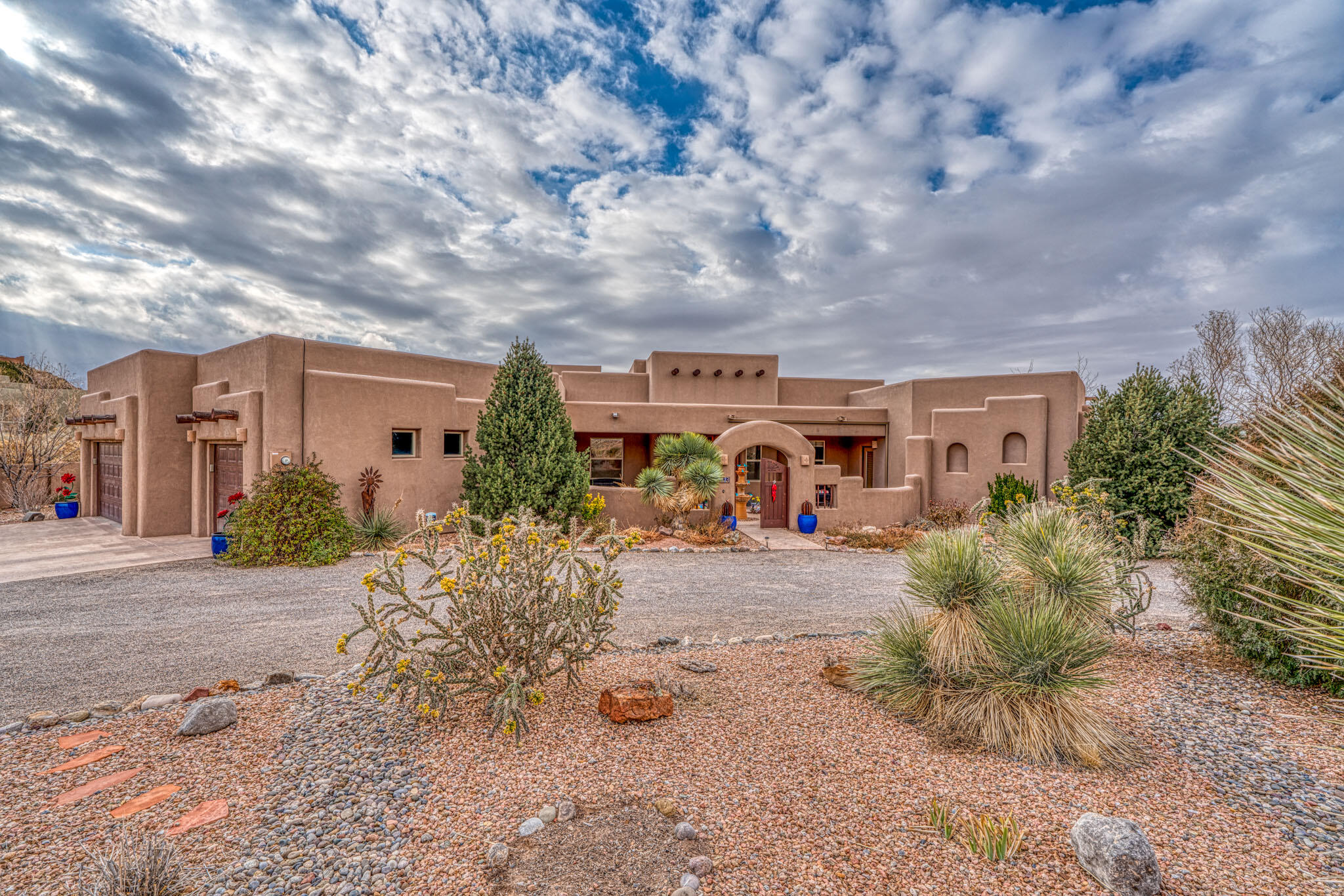 This stunning luxury home, custom designed for comfort and style offers single level living with breath taking views of the Sandia Mountains. It features four spacious bedrooms, a three car garage and an expansive primary suite with an oversized bathroom and well organized closet to keep things visible and accessible. The lay out includes a separate wing for the three additional bedrooms, providing privacy and convenience. The inviting open floor plan boasts a high end chefs kitchen with six burner stove perfect for culinary enthusiasts. The large patio wraps around the rear offering plenty of room for cozy dining by the gas fireplace in the covered area or sunning on the open patio. It's the perfect outdoor oasis for gatherings & relaxation. The laundry room is15x12 with tons of storage