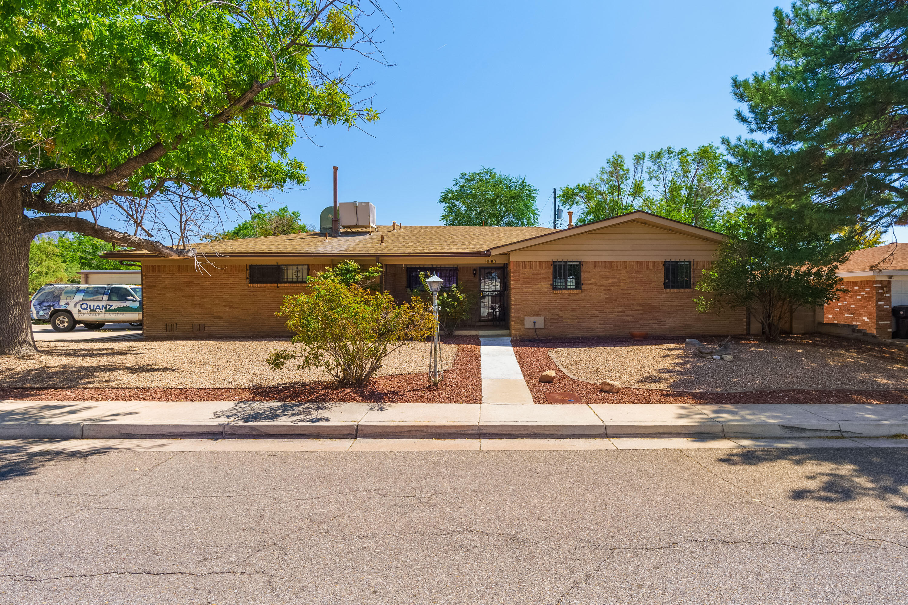 Welcome home to this beautiful single level brick home nestled on a corner lot! A perfect residence for a multi- generational family, complete w/a separated in-law or guest quarters with its own private entrance: including 1 bedroom, full bathroom, kitchen w/new appliances, private living area w/fireplace,  & its own heating/cooling & water heater, providing flexibility & privacy for visitors or extended  family! Main house boasts warmth, style &  sophistication, w/ handsome wood tile flooring throughout! Spacious kitchen offers an abundance of cabinetry, quartz counter tops, 2023 & lovely adjacent dining area! The inviting living areas are bright & open, perfect for relaxing or entertaining! Stylish, REMODELED full hall bathroom, 2020 & master bathroom w/vanity & tiled showered! MORE...