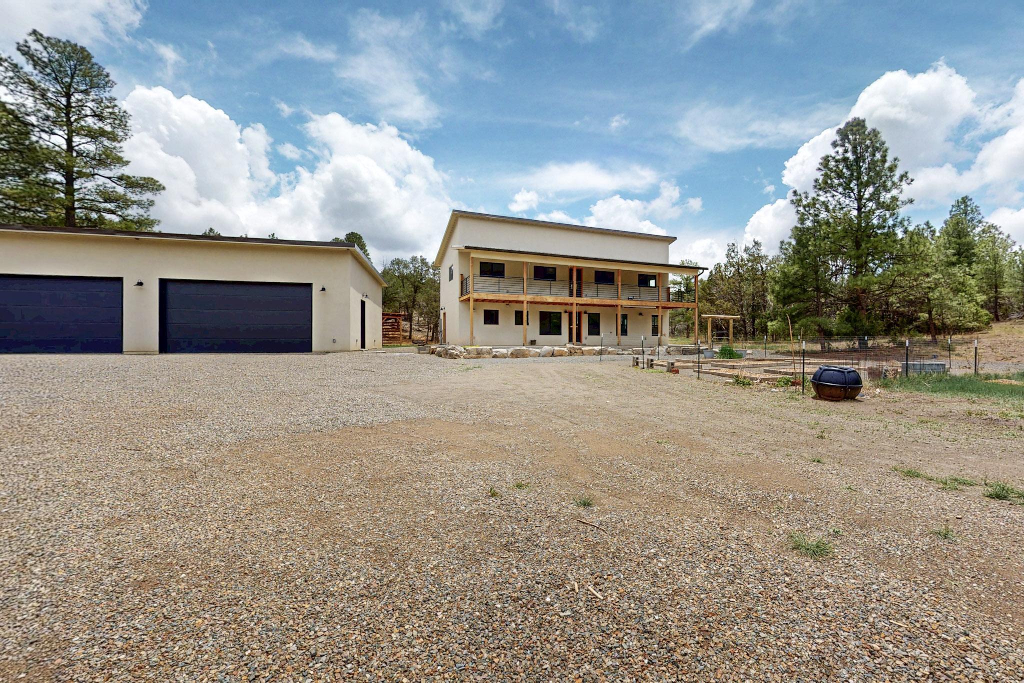This stunning custom-built home seamlessly combines luxury, comfort, and functionality, set on over 13 acres of picturesque land surrounded by towering ponderosa pines. Every detail has been carefully designed, from the solid 2x6 framing and blown-in insulation to the high-performance Anderson windows that flood the home with natural light. The advanced six-zone LG inverter heating and cooling system, paired with two heat pumps, ensures you'll enjoy year-round comfort in every corner of this exceptional home. The kitchen is a chef's dream, featuring top-of-the-line appliances, including a full-size fridge and freezer, custom drawer-based cabinetry (with hidden top drawers for added sophistication!), a massive quartz island with a beautiful waterfall edge, and a sleek stainless farmhouse