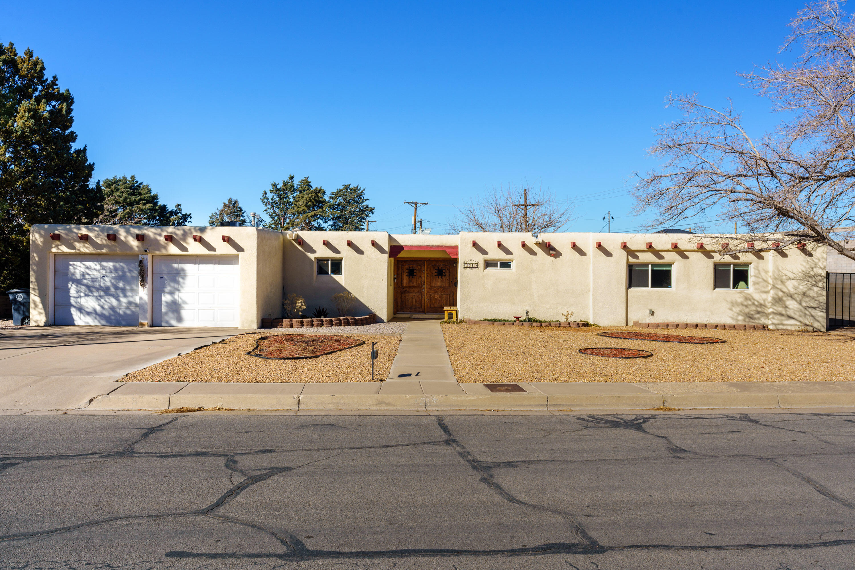 Pueblo home on oversized lot w/ side yard access-room for all your toys! Timeless southwestern charm exudes in this home with exposed vigas, tongue & groove ceilings and vibrant colors complete the home. Entrance is highlighted with solid wood doors and spacious foyer. Enjoy open concept floor plan-living room is illuminated w/ natural light, featuring wood flooring, and finished w/ brick fireplace. Formal dining is off the living room, which opens up to the bright and upgraded kitchen. Kitchen features SS appliances, custom cabinetry, & granite countertops. Large laundry room w/ extra storage. Spacious primary suite has private upgraded bathroom w/ tile shower & double vanity, backyard access, & great closet space. Backyard has large covered patio & clean slate yard w/ great potential.