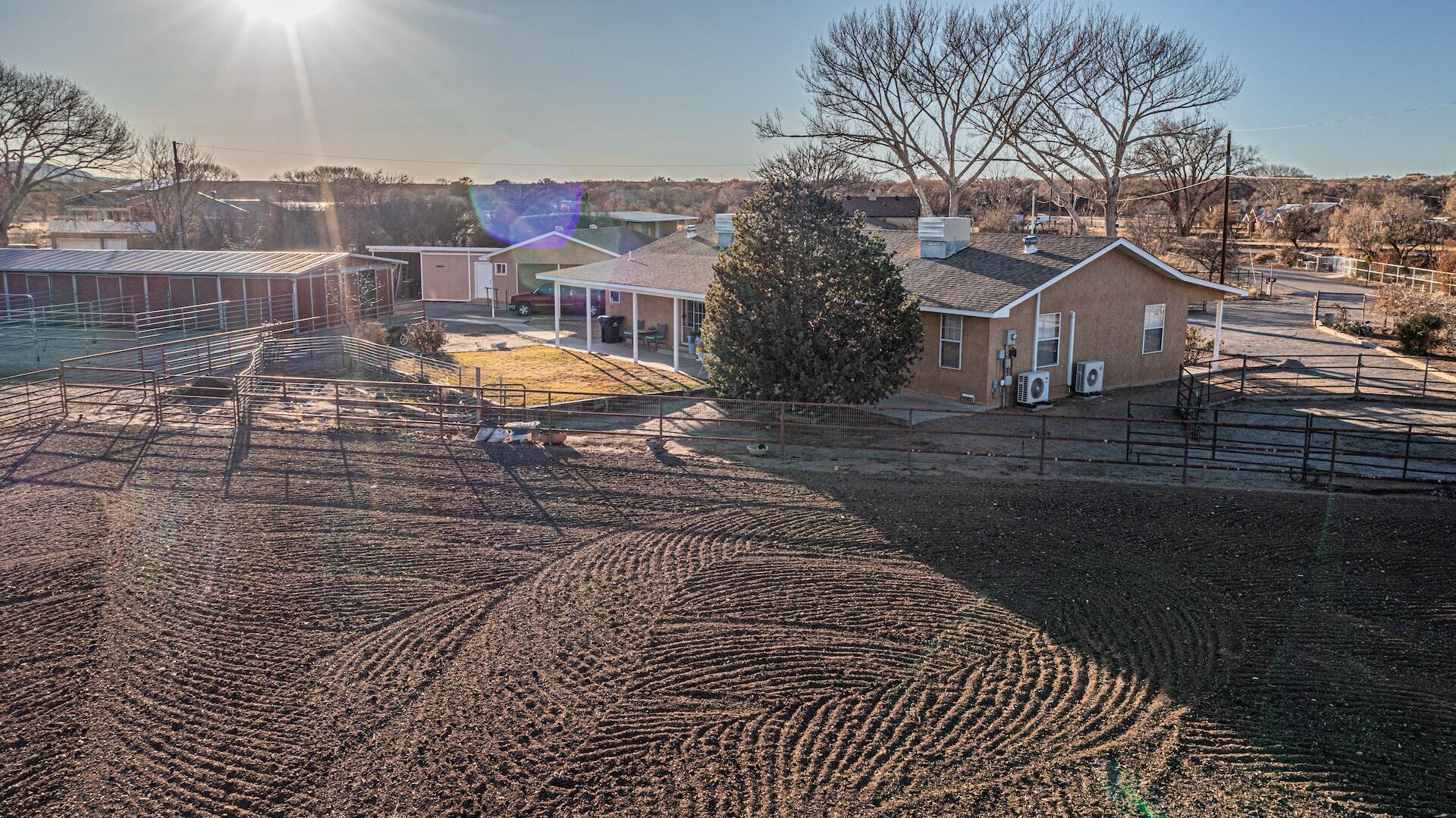 Discover your dream property in the heart of Bosque Farms! This stunning home sits on nearly 2 acres at the end of a quiet dead-end street, offering privacy, charm & endless possibilities. Inside, you'll find modern comfort with two energy-efficient mini-splits and a cozy pellet stove to keep you comfortable year-round. The pasture will remain lush and vibrant, thanks to the efficient sprinkler system. The beautiful master suite boasts an expansive walk-in closet, perfect for all your storage needs.For horse enthusiasts, this property is nothing short of paradise. It features a 60'x28' barn with four stalls and a washroom, a spacious 40-foot round pen, and a professionally designed 160'x120' arena with a cattle catch pen. Whether you're into riding, training, or caring for livestock,