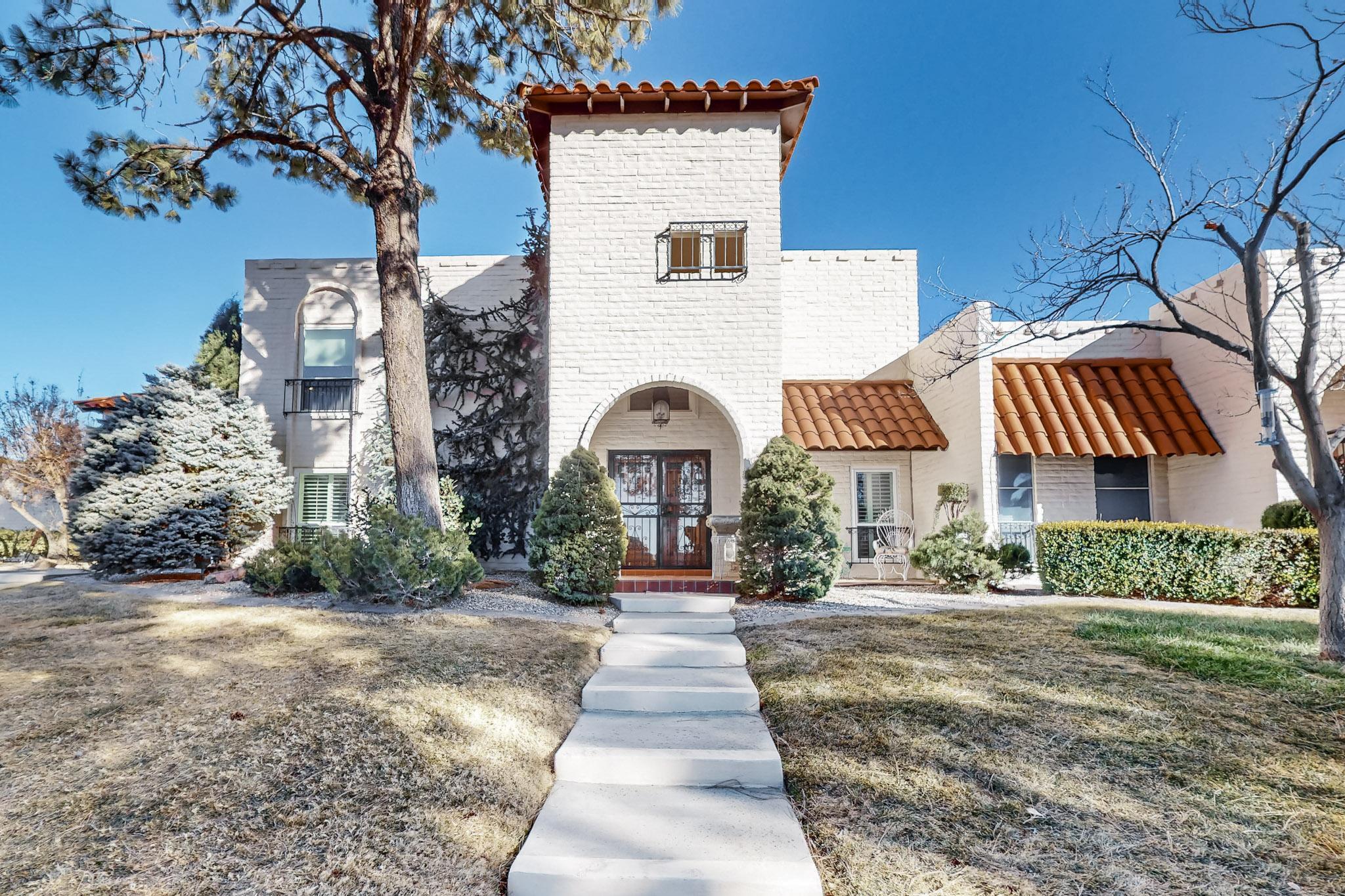 Welcome to this lovely, bright townhome with a touch of Tuscany in Villa Serena. Lofty beamed ceilings over the expansive living room, with its tile floors, cozy gas fireplace and sunlit windows. A roomy kitchen and separate dining room add to the great entertainment space and a downstairs primary bedroom means no climbing at the end of the evening. Across the small courtyard is a separate studio, heated and cooled, that would make a great office or yoga space. Upstairs are two ample bedrooms, bathroom and a balcony that looks out to the Sandia and Manzano Mountains. You'll be just a few steps from the pool and clubhouse when the weather warms, and just up the road the Canyon Club at Four Hills offers golf, dining and socializing.