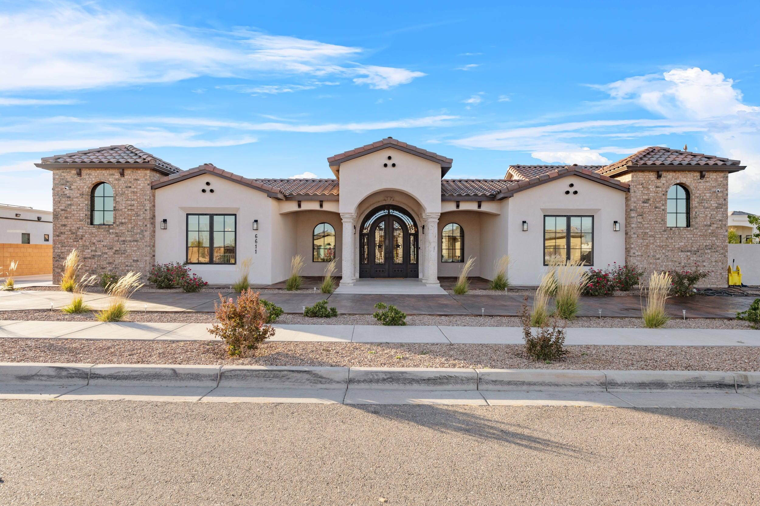 Welcome to Casa Candalaria, a masterpiece of sophistication and design nestled in the exclusive Petroglyph Estates. This breathtaking estate spans nearly 5100 sqft, offering an unrivaled blend of grandeur, comfort, and modern luxury.  Step through the grand entrance and into a world of refined elegance, where soaring ceilings, custom brick work, and floor-to-ceiling windows showcase panoramic views of your own personal oasis. The grand room is a culinary dream boasting sleek quartz countertops, and an oversized island perfect for entertaining. Call today for a personal tour of your dream home and become a part of this exclusive community.