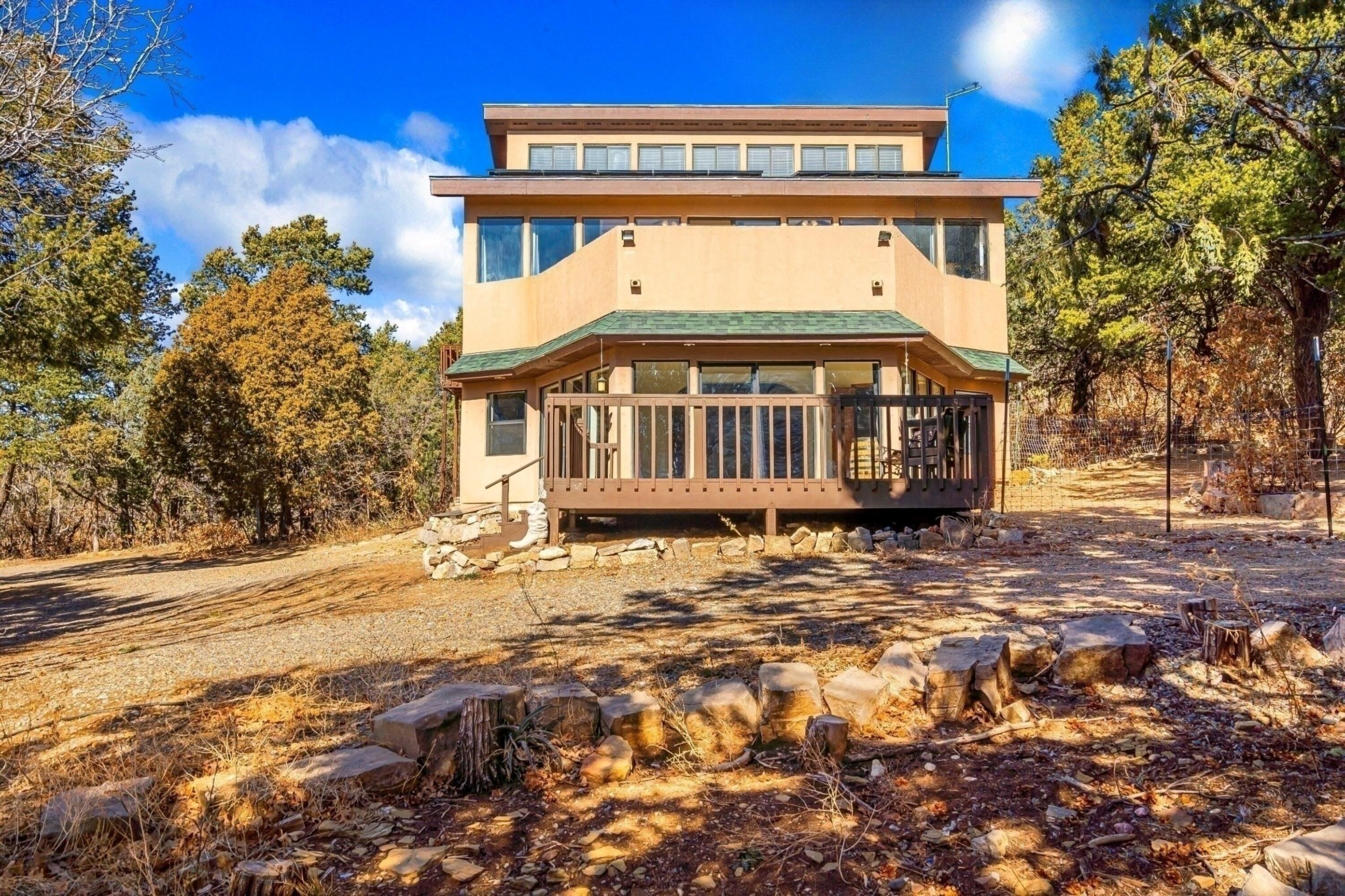 Your East Mountain escape awaits! Tucked away on 4 wooded acres just a short drive from Albuquerque, this home features unique architecture that highlights mountain living. Walk out to the large deck and enjoy your morning coffee, taking in the crisp mountain air. Entertain in your large kitchen with updated appliances. Spacious primary suite with a walkout to the large balcony. Primary bath features two sinks and a soaking tub. Ascend the spiral staircase to access the third floor, complete with a loft, space for an office, and abundance of storage space, and a bonus area that can fit a bed. Owned solar system. Hauled water system in place with 1,500 gal. storage tank. Private well is present and works. *SELLER TO PROVIDE $4,500 CREDIT TOWARD WELL HOOKUP AT CLOSING*