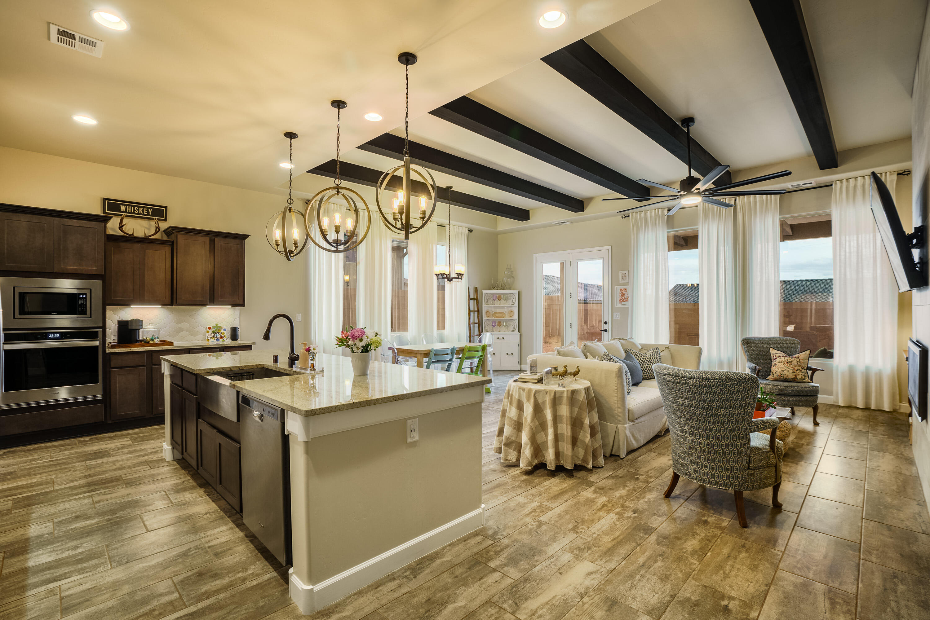 Assumable VA mortgage at 4.25% interest rate. PID is paid in full. Modern home w/ beautiful open concept floorplan! Raised wood beam ceilings, 8 ft doors, modern light fixtures, modern sleek tiled fireplace, upgraded 5'' baseboards, and upgraded tile floors among the many features. Granite counters,  charcoal colored cabinets, sleek backsplash, large island with bar seating, Whirlpool SS appliances, pot filler over gas cooktop complete this gourmet kitchen. Spacious primary suite with glorious bathroom including a walk-in tiled shower & double vanity. 2 additional bedrooms plus a flex room-den, office or 4th bedroom with French doors and closet. Full hall bathroom and additional powder bath. Covered patio, mountain views, and ready for your creative landscape ideas.