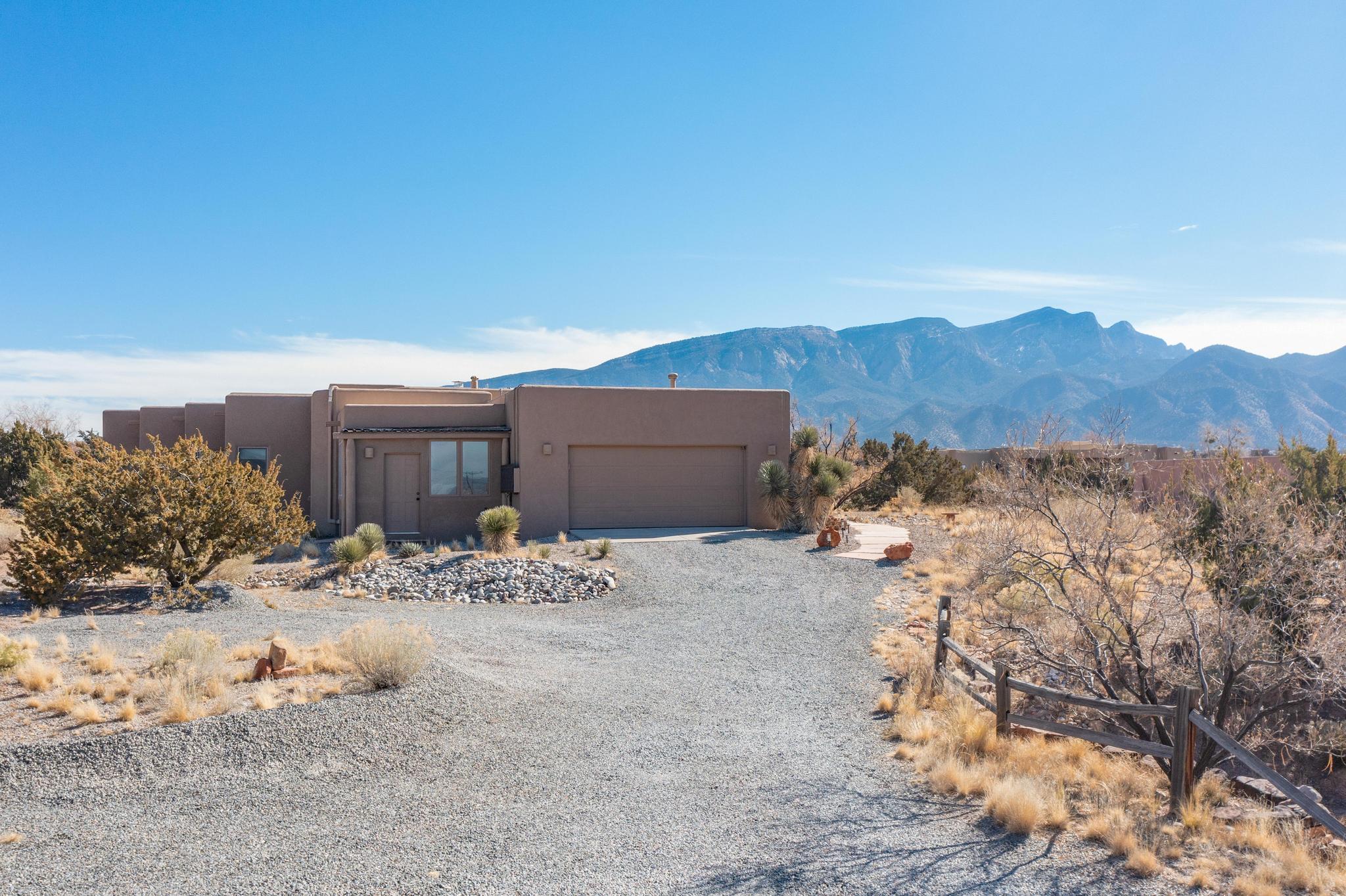 Beautiful custom, Southwest designed for comfort & style with amazing Sandia Mountain & city light views! This home is located just 3 minutes from I-25!  Southwestern charm throughout, vigas, nichos, kiva fireplace, brick flooring, wood ceilings and beams. The spacious kitchen is complete with stainless steel appliances, granite counter tops & custom cabinetry. The living room is inviting with large windows framing the mountain views and allowing for an abundance of natural light. The large primary bedroom has a spacious ensuite with double sinks, walk-in shower with beautiful custom tile work and extra storage. Two additional bedrooms plus a bonus room. Create a home office, a guest suite, or a hobby room to suit your lifestyle needs. The stunning home includes owned solar.