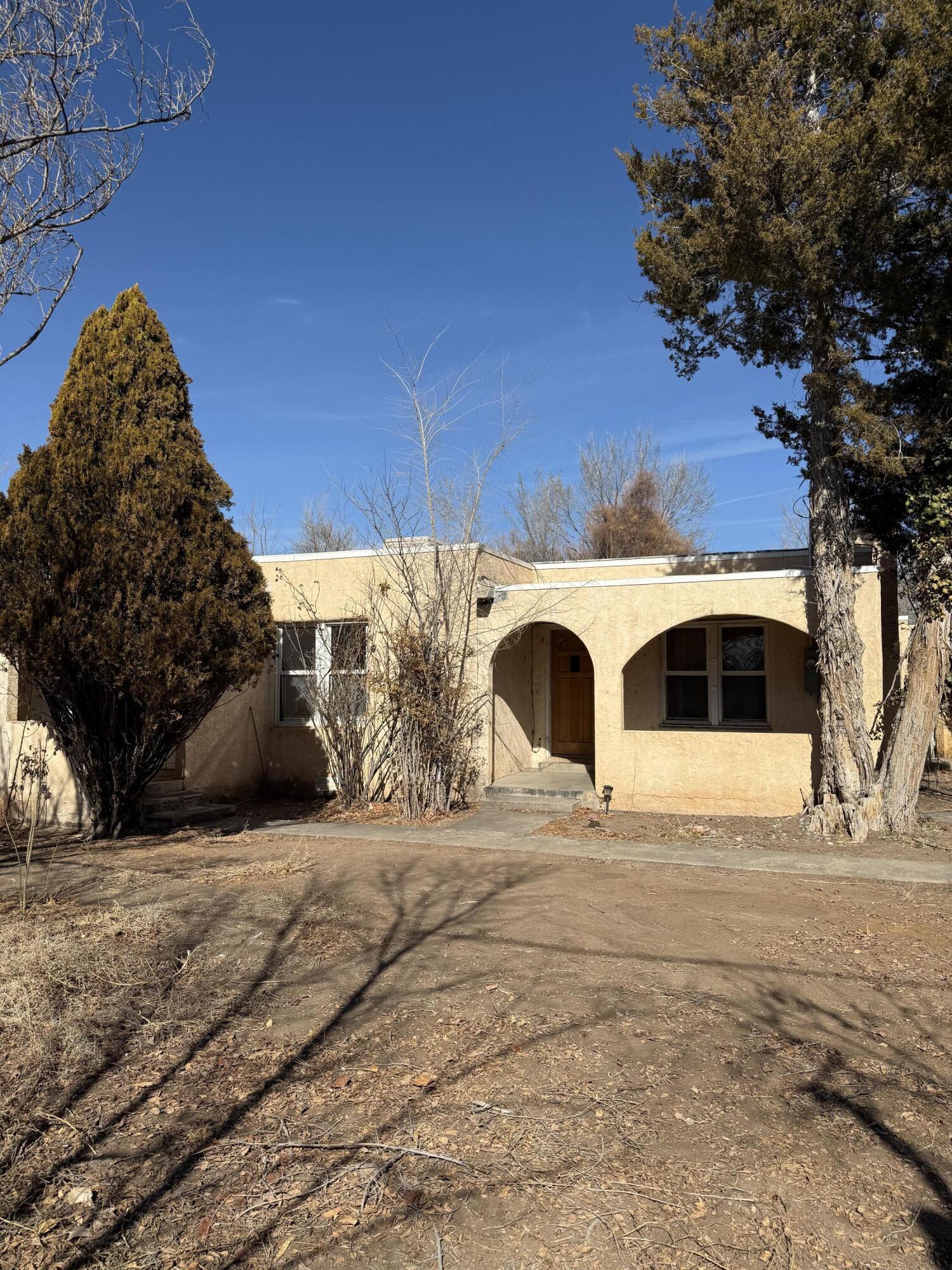 Discover this South Valley gem, where 1950s charm meets modern potential. This unique home features an attached casita, a cozy wood-burning fireplace, and a spacious covered porch perfect for relaxing or entertaining. Though compact, it offers deep storage throughout. The detached garage includes a workshop, adding extra functionality.Backing up to Rio Bravo, the private lot is filled with mature trees, lots of space and is ready for your vision. Whether you dream of a lush garden or an outdoor retreat, this space is yours to transform. Don't miss this opportunity--come see it today!