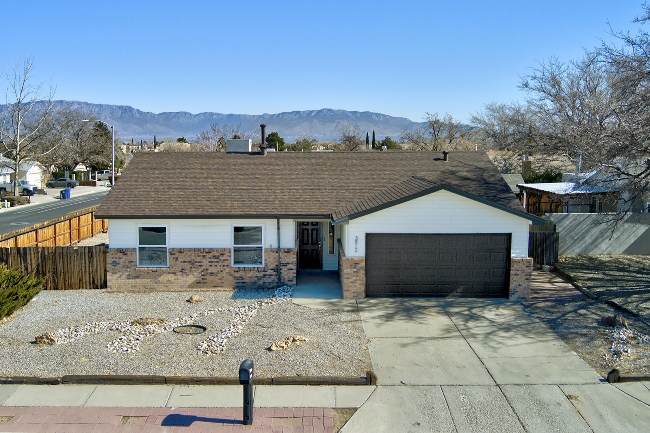 Welcome to this beautifully updated single story home featuring 3 bedrooms, 2 full baths, and a 2 car garage situated on a corner lot with views of the Sandia mountains. Modern updates throughout, including new luxury vinyl plank flooring, new carpet in the bedrooms, new roof, new water heater, new windows plus freshly painted throughout! Cook with ease in the newly remodeled kitchen, featuring stainless steel appliances, elegant granite countertops, a stylish tile backsplash, and an inviting kitchen island with bar seating. Bright and airy open floorplan, complete with a cozy fireplace in the living area. Primary bedroom offers a spacious walk-in closet. Large backyard offers endless possibilities for outdoor living and entertaining.