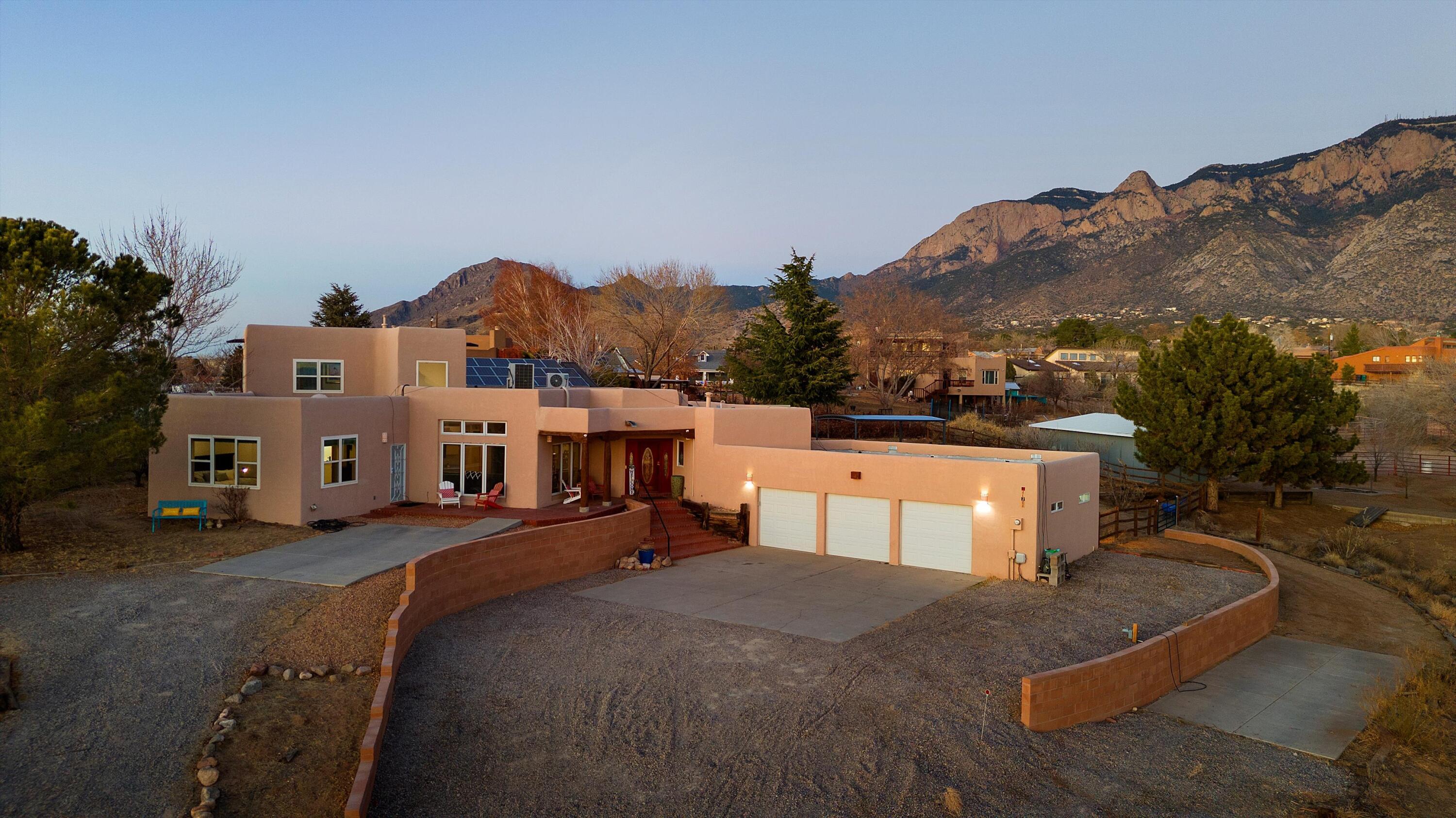 North Albuquerque Acres property w/breathtaking views & well-designed layout. 2 primary BR's; 1 w/full bath & 2nd w/private entrance to back patio, 3/4 bath w/roll-in shower. Upstairs office, or fourth bedroom w/cozy corner kiva gas fireplace & balcony w/stunning views.  Improvements include; 7 mini-splits '21, wtr htr '25, septic '20, new blinds in some rooms, outdoor office '23, newer sinks and cabinets in primary 1 and hall bath, new light fixtures in entry, dng rm & nook '25. Professionally painted kitchen cabinets with new hardware '25 & new SS appl '25.  Granite island and pantry in kitchen w/separate coffee bar. Step outside to front porch for expansive city views or to bkyd w/majestic Sandia Mountain views, cvd patio, hot tub, office w/addtl wkspc not incl in sf! Motivated Seller!
