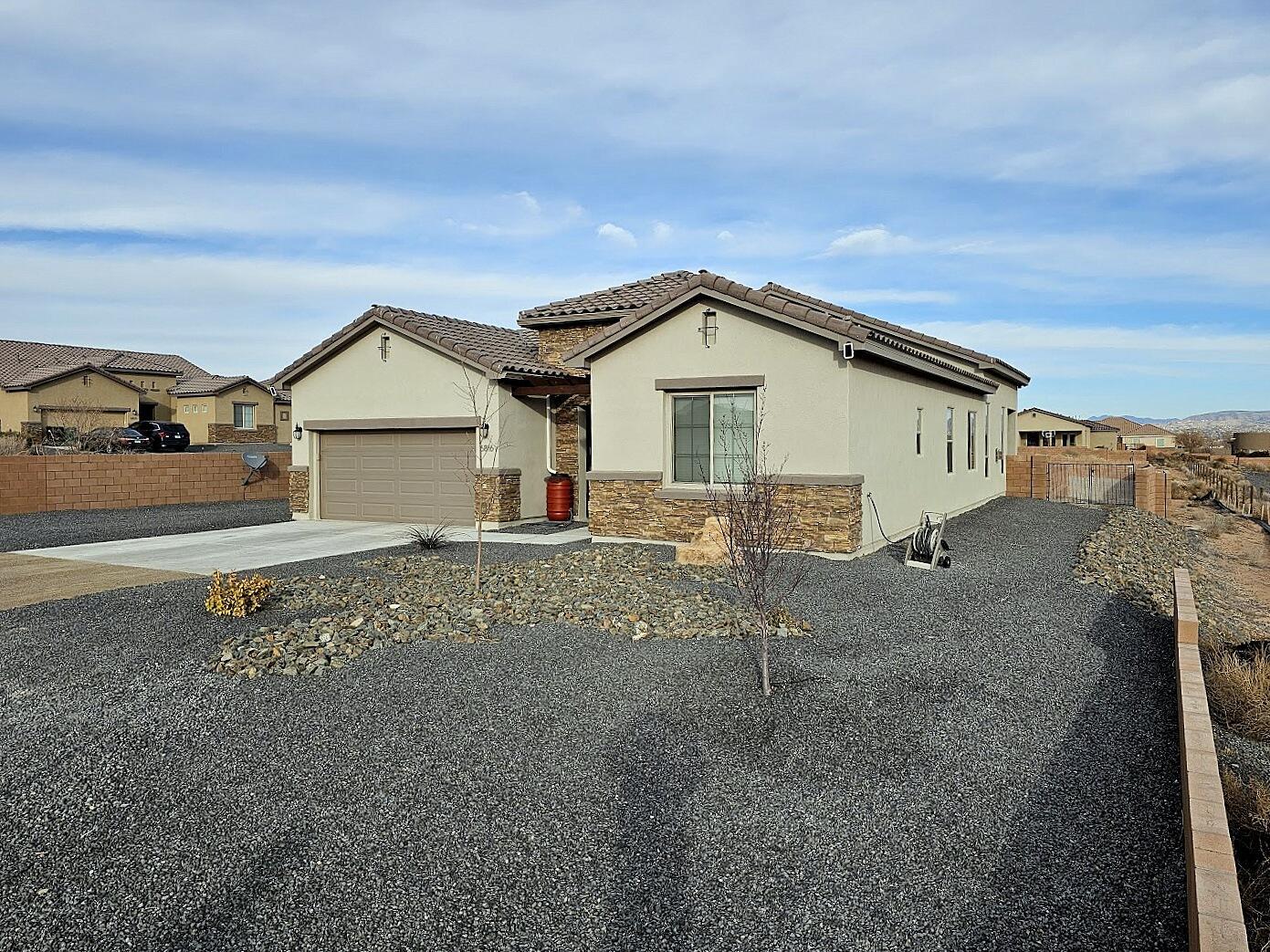 This stunning Hakes Brothers home, built in January 2023, sits on a spacious 0.5-acre lot and showcases breathtaking, unobstructed views of the Sandia Mountains. The thoughtfully designed 2,357 sq. ft. floor plan offers 4 bedrooms, 3 baths, and a 2-car garage, blending comfort with modern elegance. High-end upgrades include a gourmet chef's kitchen, stylish upgraded tile in main living spaces and wet areas, soaring 8-foot doors, a sleek 36'' contemporary gas fireplace, and beautifully hand-textured walls. The fully walled lot provides ample space for a shop, RV, trailer, or toys, while the private, landscaped area features Synlawn and a covered patio--perfect for relaxation. The backyard has been leveled and is ready for your imagination--design the outdoor oasis you've always wanted. No HOA