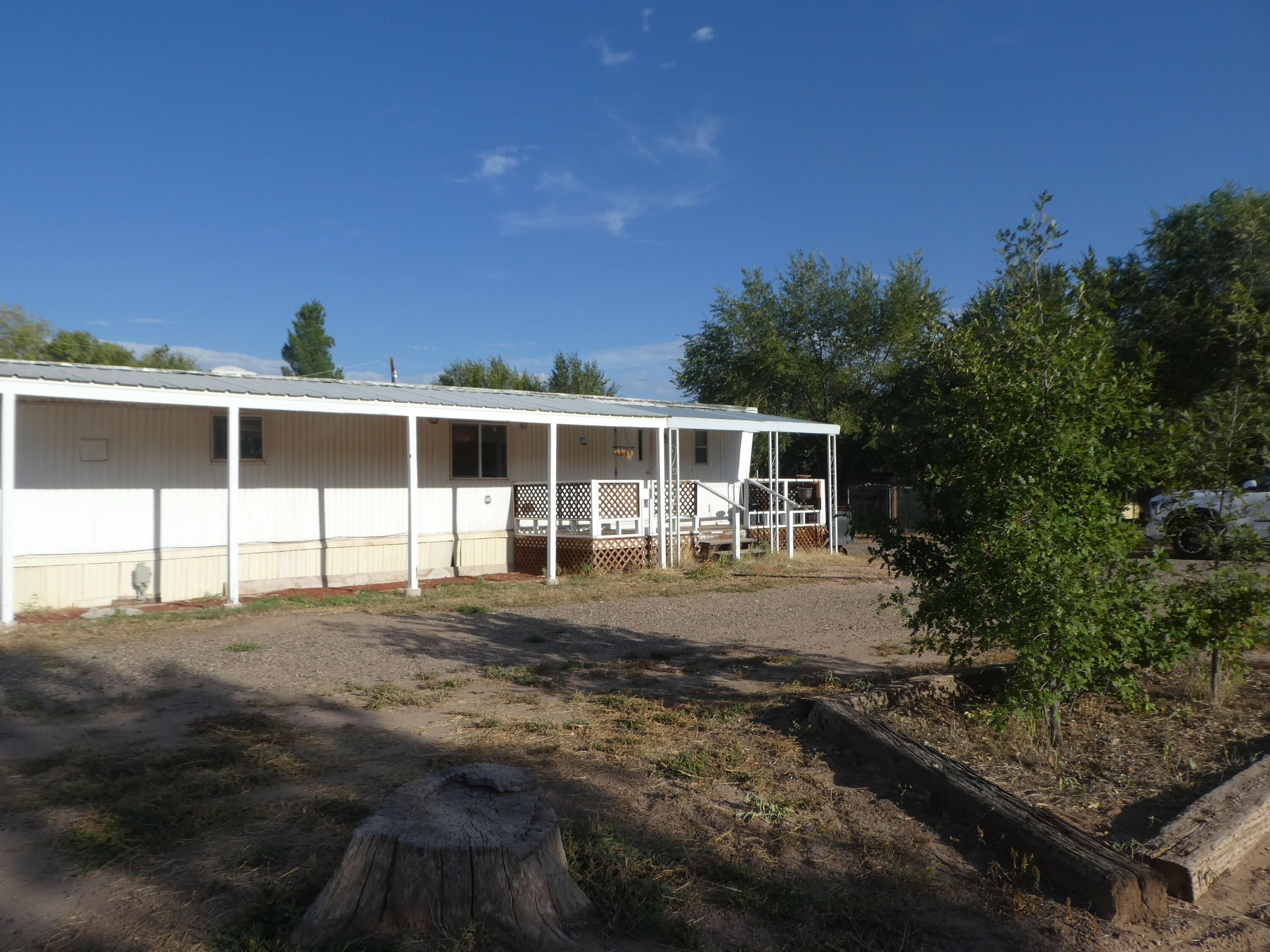 Affordable Bosque Farms! Great location!  Single -wide on a nice half acre. There is added living space with the two additions. Sellers have replaced the flooring in the two bedrooms and the added living room.  Nice decks on the front and back of the home. Refrigerated air. Fresh paint. Large storage building in which the sellers replaced one half of the roof. Irrigation well with newer pump. City water and sewer.