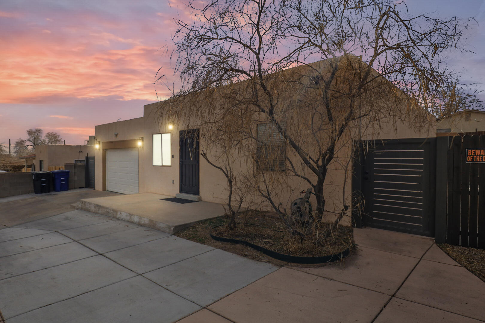 Beautifully remodeled single-story home with stunning landscaping, an outdoor kitchen, and a gas firepit--perfect for entertaining or relaxing! The remodel includes granite counters, custom-tiled baths, a torch-down roof, combo AC/furnace, and 200-amp service. The floor plan offers a private primary suite and open living space with no carpet. A covered patio with a wood ceiling, fan, fridge, and grill, with a sprinkler/drip system. An electronic security gate provides parking for 3+ cars, allowing the garage to double as an office or game room. Just three blocks from Pat Hurley Park with breathtaking Sandia and city views! Easy access to I-40, the bosque trails, and ABQ BioPark. A must-see!