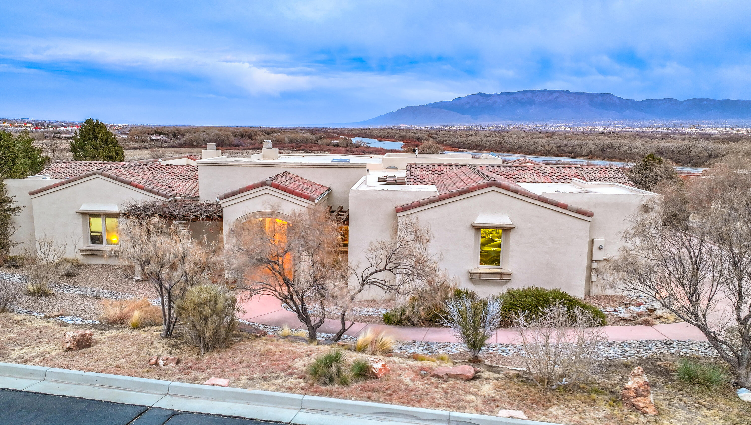 Beautiful custom home located in the elegant gated community of Oxbow Bluff. Breathtaking mountain and Rio Grande river views from inside and outside of the home. This is truly a one of a kind location. Home features a large great room with stone fireplace, wood viga beams on the ceiling and a bay window. Gourmet kitchen with executive cabinets,  chefs delight gas cooktop, wall oven and built in custom refrigerator. Primary suite with separate retreat with fireplace. Elegant bathroom with large custom tiled shower and garden tub and walk in closet.3 additional bedrooms and 2 with their own bathroom. Large office and laundry /craft room. 4 car stacked garage for all the toys and vehicles. Large backyard covered patio to enjoy the perfect NM evenings and much more!