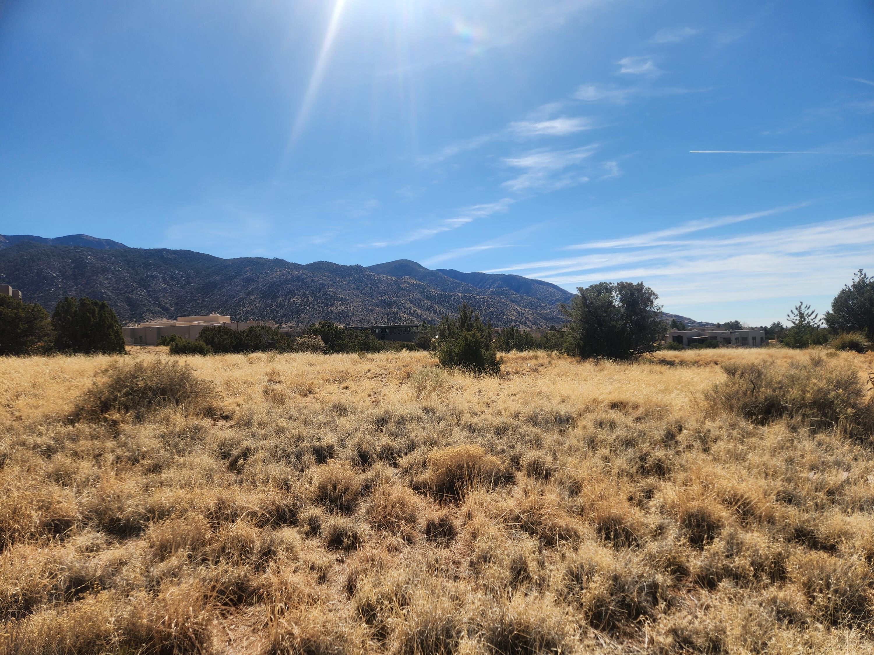 Vacant lot ready for building in Mountain Highlands at High Desert! Panoramic views of the Sandia Mountains! Close proximity to Tramway Boulevard & the Sandia Peak Tram. Located in one of Albuquerque's most desirable neighborhoods. This is your opportunity to own and live in a luxury setting.  The lot is mostly level topography.  Southwest natural landscaping, quiet convenient location. Pride of ownership abounds in this neighborhood. Steps away from the Sandia Mountain Wilderness.