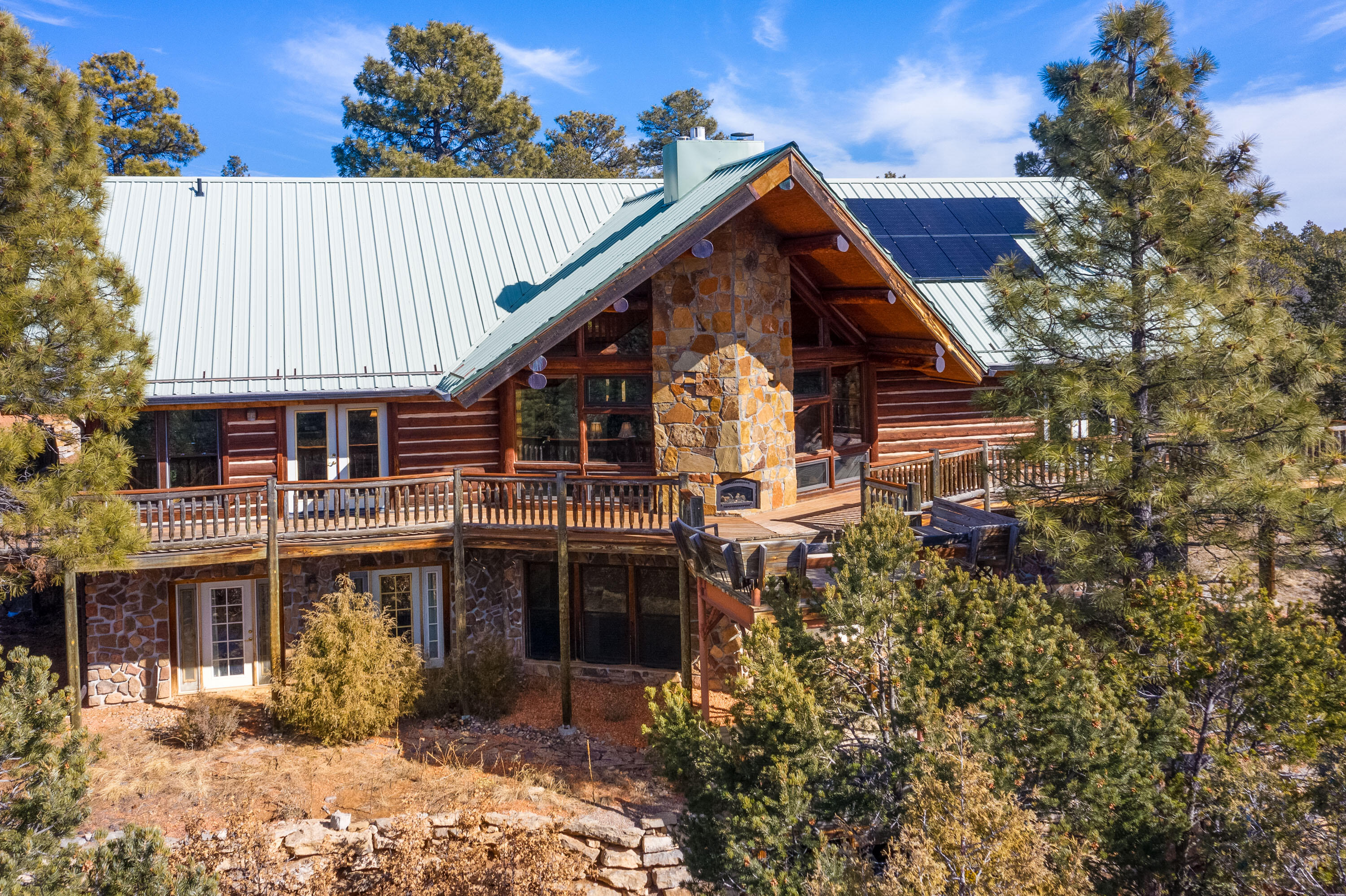 Stunning, custom log cabin in a peaceful, secluded location, 20 mins. from Tijeras. Scenes for the TV series ''Graves'' were filmed here! Gated entry & circular driveway led you to the front bubbling koi pond foyer. Tongue & groove ceilings & clerestory windows set the cozy cheerful tone as you walk thru the front door. Views & natural light throughout! Huge kitchen w/ granite countertops & hickory cupboards. Radiant floor heat & a total of 5 fireplaces. One is an efficient ''Tuli Kivi'' imported Swedish soapstone fireplace. Solar is owned. The wrap-around deck is hot-tub-ready. What a wonderful place to entertain! Well thought out floor plan w/ primary living spaces on main floor. Media room or in-law wing downstairs. Don't miss the art studio/workshop/8 car garage. MORE..