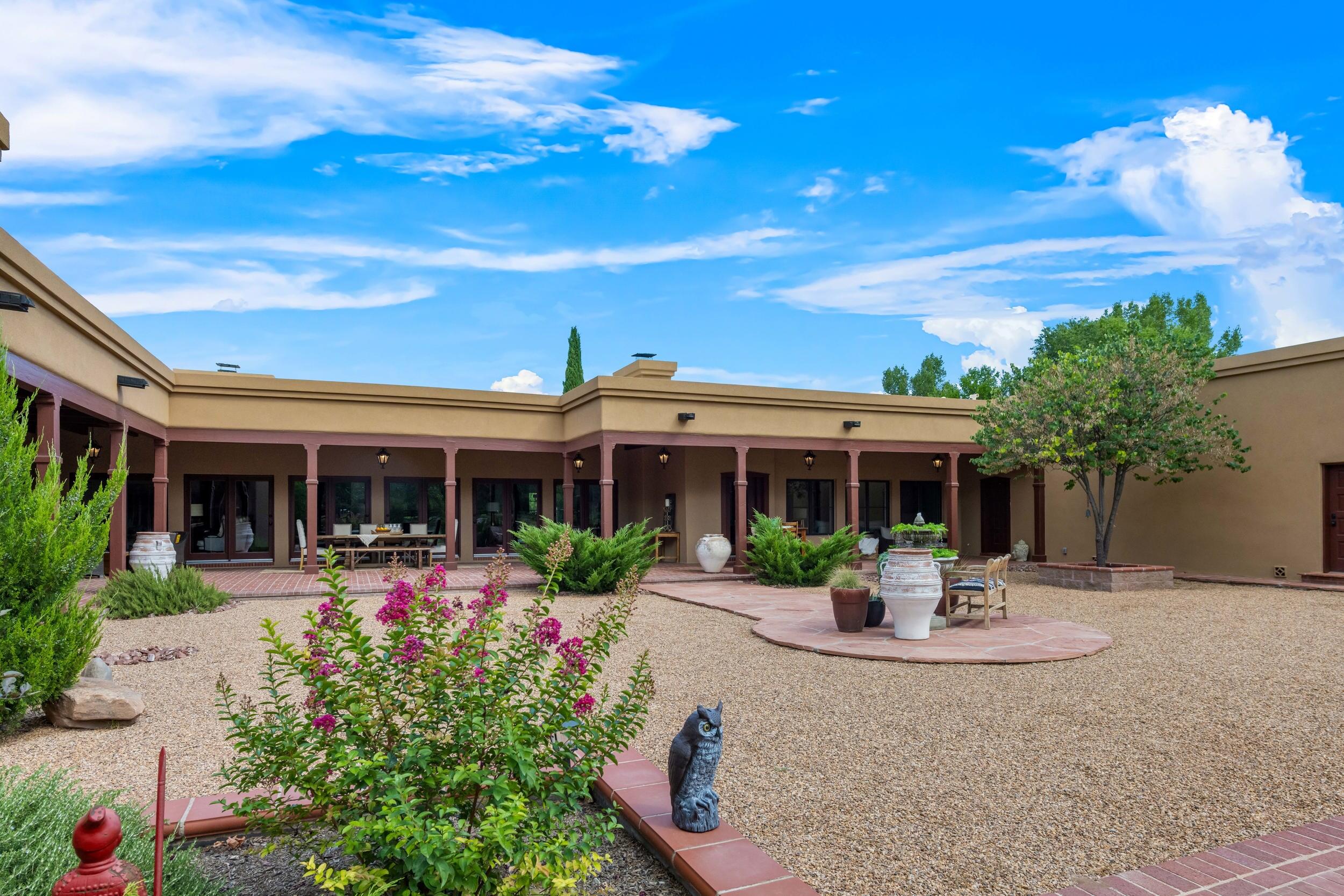 ''Los Poblanos'' style hacienda tucked away on 3.4 acres, the rural side of the gated Bona Terra community, a beloved luxury neighborhood... enjoy pedestrian/bike trails along the river!  You will fall in love with the blend of current style, comfortable amenities and Santa Fe character.  This fine quality construction boasts artisan design Spanish tile, elegant hardwood floors, wood beams, Pella wood clad windows, 3 brick Fireplaces, no interior steps! Brick floors & wood vigas wrap the covered portals on this classic U-shaped hacienda,  extending the living space. Schedule to view this amazing estate over 6000sq ft of luxury living, gardens, mature trees &  horse facilities. 3 Private Water wells + city water available.  MORE
