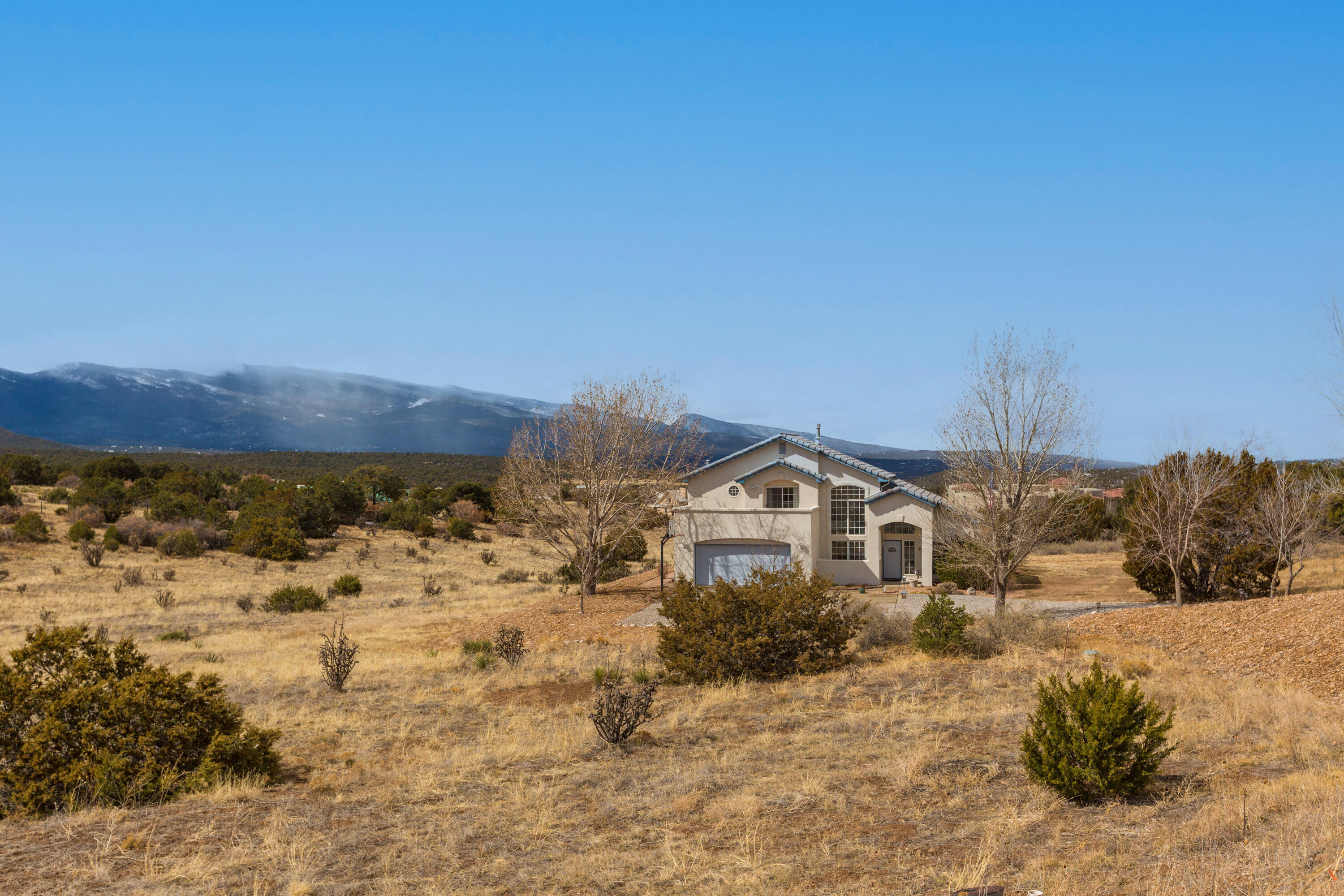 This custom 2 story home in the picturesque East Mountains is a true gem, offering a perfect blend of modern amenities and natural beauty. Inside, you'll find thoughtful details such as built-in speakers, intercoms, bookshelves, and a central vacuum system throughout, providing ultimate convenience. The home offers 2 primary bedrooms with the larger room upstairs which includes a sitting area w/ built-in storage, a large bathroom with double sinks, a luxurious garden tub, a spacious shower with two shower heads, and a private deck perfect for enjoying the views. The heated downstairs basement is spanning 441 sq ft and offers endless possibilities, with a half bathroom and plenty of space to tailor to your needs -whether that be a home theater, workout room, or workshop, you get to decide.