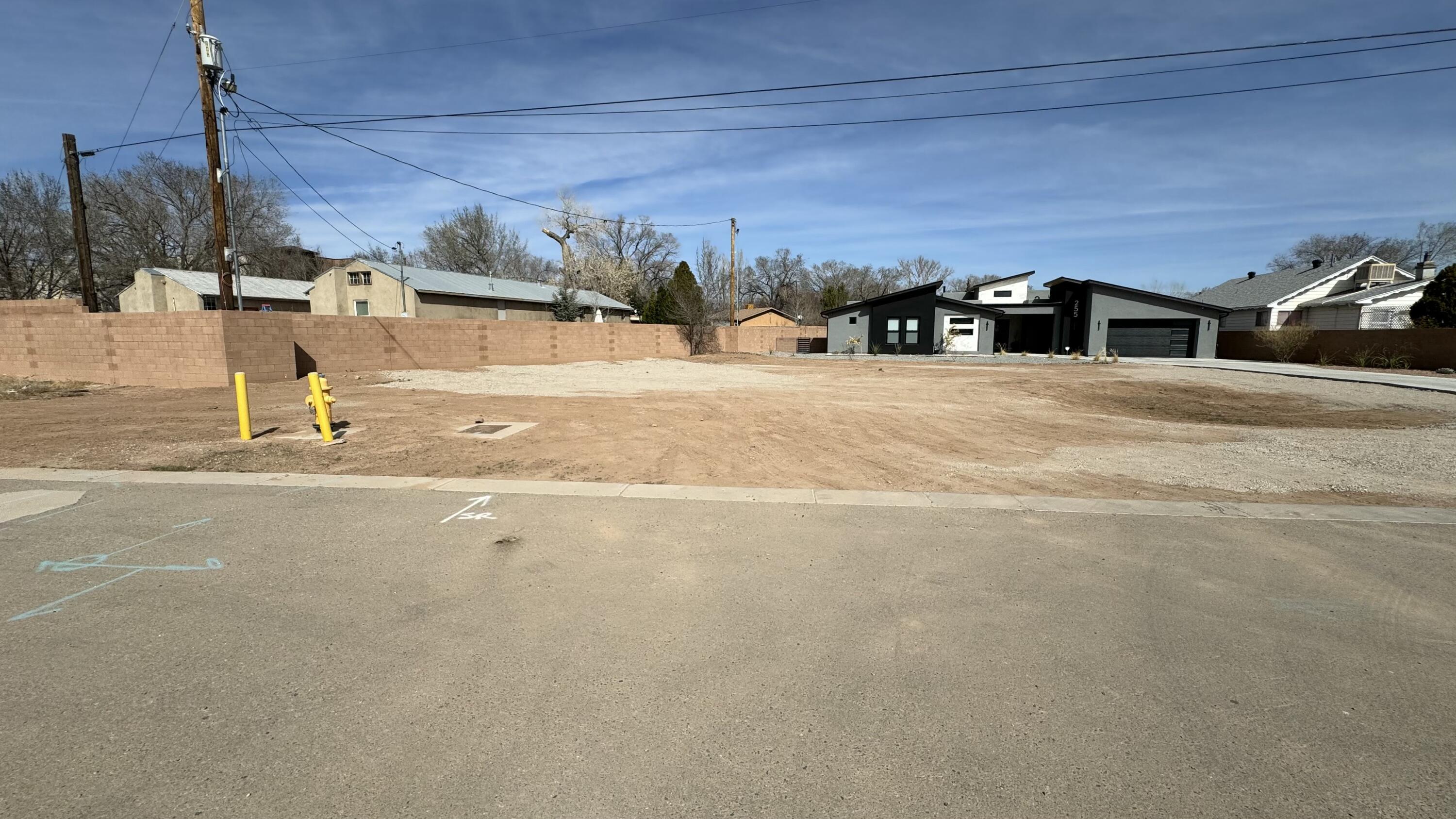 Bring you Dream Home Plans and Look at this beautiful flat corner lot in gated community with Awesome location. Close to great restaurants, shopping and Railrunner train station.  Lot is just across the acequia from Los Ranchos great for biking and walking the dogs.  2700sqft building pad already installed ($10,000 savings)  All utilities are stubbed in and ready to go.