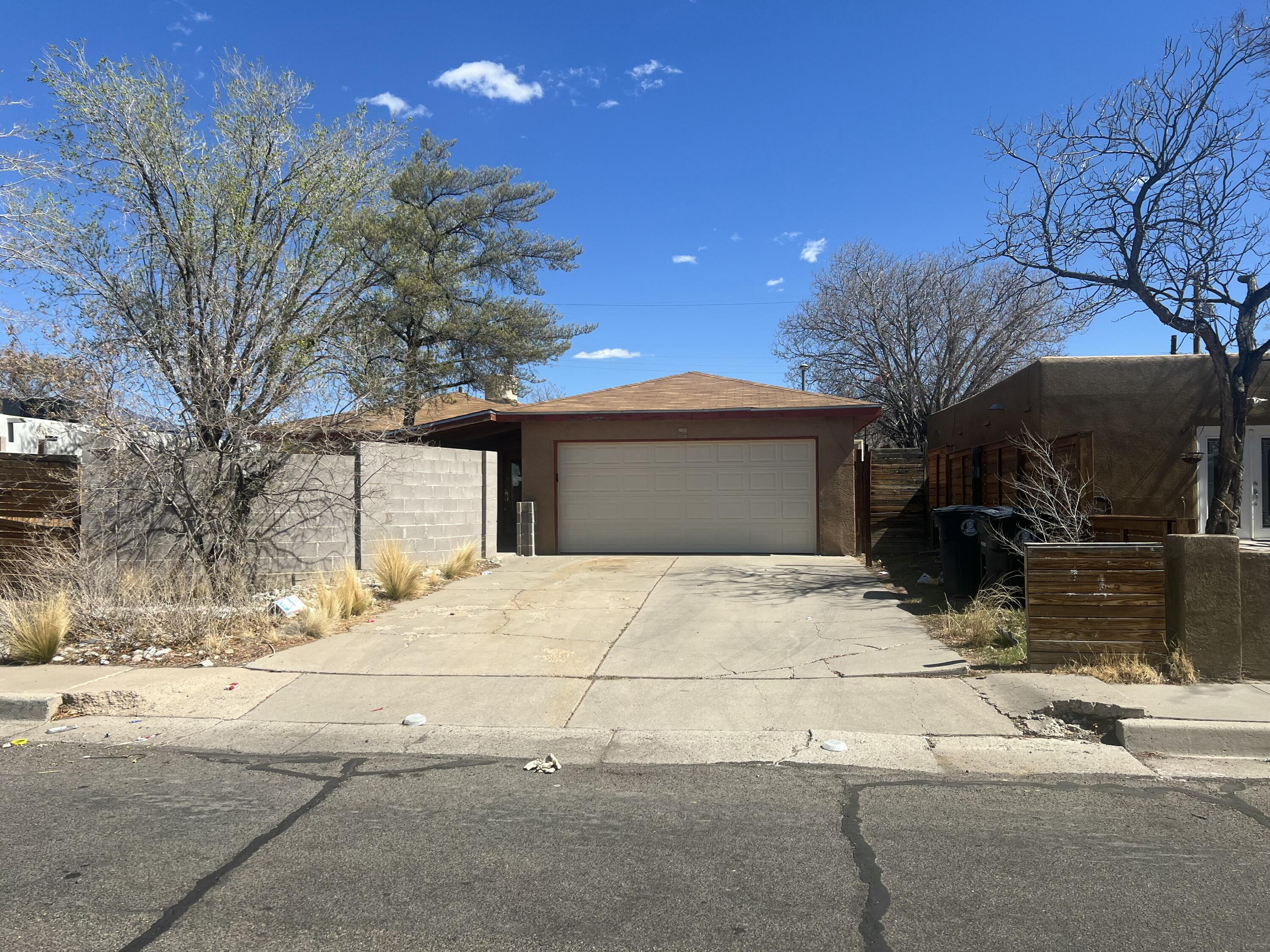 Are you looking for a project? This 3 bedroom, 2 bath home is waiting for you!  Featuring a front courtyard and alley access to the back, this home offers approx. 1365 sqft of living space, with unique custom cabinets and butcher block counters in the kitchen, built-in shelving and gas log fireplace in the living room. New garage door, some updated windows, wood floors in part of the house, guest bath is gutted. Centrally located in the Uptown area, the home is conveniently close to Uptown and Coronado malls, and quick access to I40. Handyman Special.