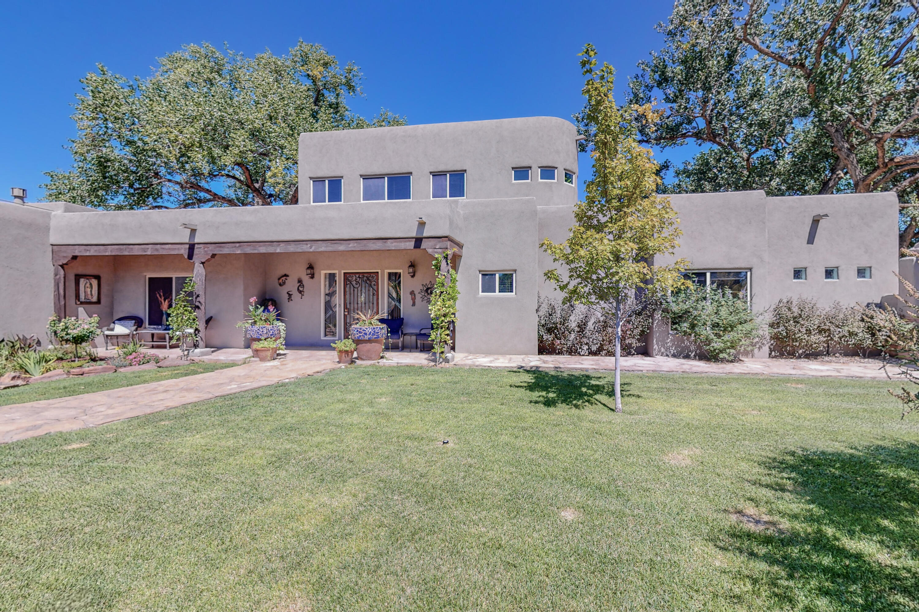 Stunning custom home on a 1 1/2 Acre lush landscaped lot with irrigation access, a 1200 sq. ft. barn, green house and dazzling features to include open concept newer custom kitchen with Quartzite countertops, stainless steel Cafe Refrigerator, 6 burner gas Z-line stove, custom island with black walnut countertop, custom laundry room, updated bathrooms with beautiful tile and flagstone countertops, stained glass windows, Kiva Fireplace, Vigas, flagstone lined walkways and full landscaped yard with mature Cottonwood trees and large grass area perfect for parties and events!  Fully fenced with electric gate, Out of ground pool is ready for summer! Hot Tub is negotiable!  Sprinkler System and Drippers! Refrigerated Air! Garage Workshop Space! Courtyard fountain.  Greenbelt area!