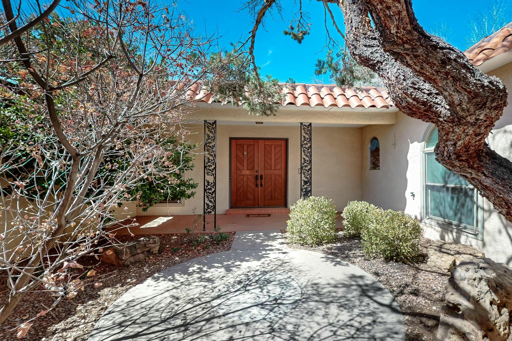 This lovely 4 bed, 3 bath, 2 car garage home is near the popular Arroyo Del Oso golf course, the prestigious Albuquerque Academy, Starbucks, Whole Foods, plus more shopping & dining. New carpet throughout! Enter the gated courtyard then into the welcoming bright entryway. There are two living areas. The den with fireplace and wet bar is perfect for entertaining, movie & game night or use as an office. The kitchen has custom cabinets, room for a table & chairs and storage. It leads into the formal dining room. Note the gorgeous front & back yards w/mature landscaping, grass, pergola & backyard access. Pella windows w/built in blinds throughout. Large sliding doors in the dining & den lead to the back patio. The gated side access may fit your boat or RV & includes a Basket Ball Hoop.