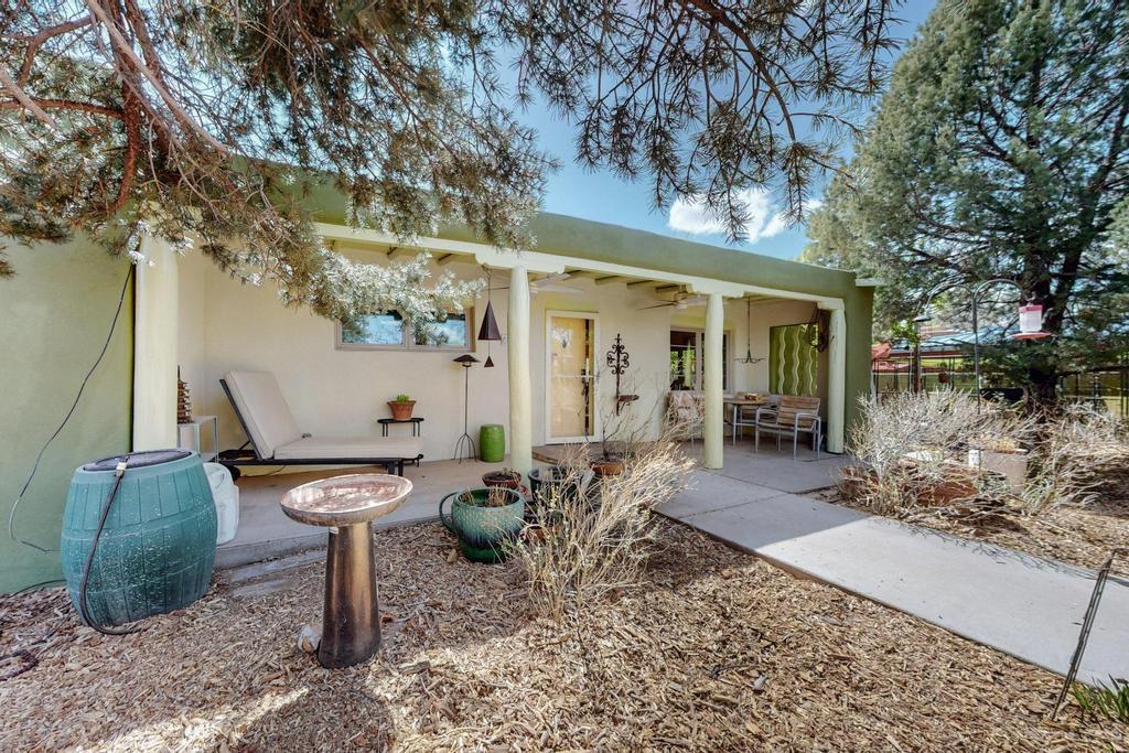 Beautiful pueblo style home in Los Ranchos! Upgrades include: TPO roof, furnace, refrigerated A/C, tankless water heater, fresh color coated stucco, thermal double pane windows, lower kitchen cabinets, sink and counter tops, interior lighting and lots more! Large living room and den, beautiful hardwood floors, beamed ceilings, 2 wood burning fireplaces, large living room plus den, covered front and back patios, private front and back yards with 2 large dog pens/runs and beautiful landscaping! Great opportunity in the N Valley!