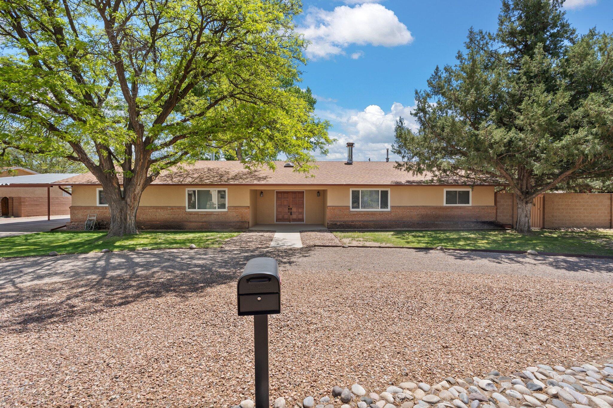 Your dream home is on the market!What an opportunity! This sprawling ranch offers a floorplan full of privacy and utility! Your new home has 4 bedrooms, 2 bathrooms, and a wet bar for entertaining! The two wings of the house are separated by 2 expansive living rooms each with a cozy fireplace. The massive laundry room features tons on extra storage space, and walk outs to both the enclosed porch and the covered patio. The backyard is east facing towards the Sandia Mountains and features a one car garage, backyard access through the back alley or the side yard, and lush established landscaping. The setting feels rural and quiet with river access just across the road for biking, running, or horseback riding.  Come live your country dreams in the city!Private well on .6 acres.