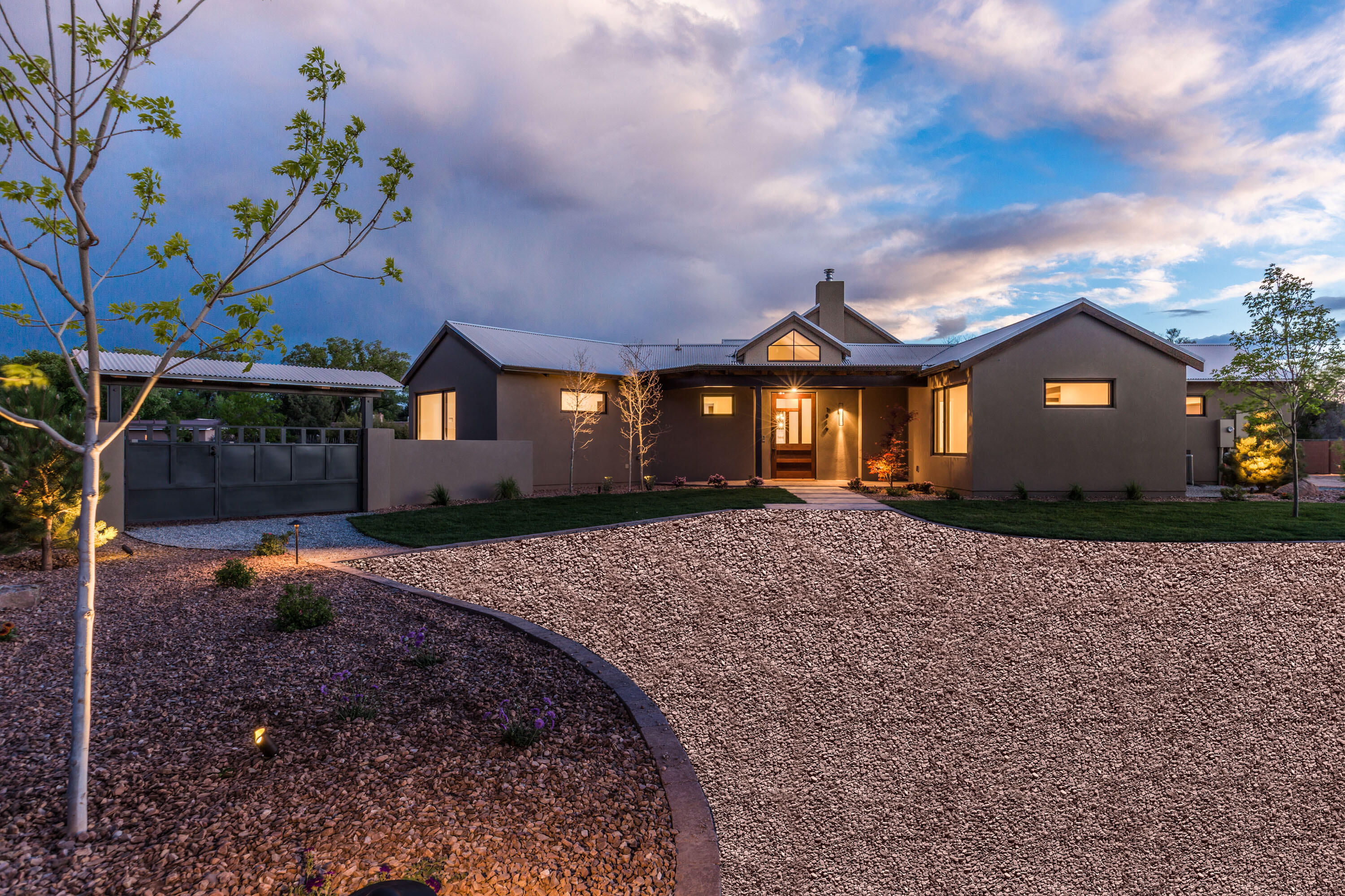 Dynamic contemporary architecture beautifully frames views of the Sandia Mountains from this lush North Valley homesite. Features include an attached casita, furniture-grade doors and cabinetry, and clean sophisticated finishes. The flexible floor plan offers 4 bedrooms all with their own en-suite bathrooms & walk in closets. The kitchen features commercial grade appliances, a large island, 2 sinks, 2 dishwashers, a wine refrigerator and walk in pantry. Expansive outdoor living areas feature multiple covered patios for enjoying the wonderful weather and an outdoor kitchen. Oversized 3 car garage, and backyard access. Enjoy close proximity to the Bosque trail for walking, biking, or running. Relish in the tranquility of this beautiful setting nestled in the heart of the North Valley.